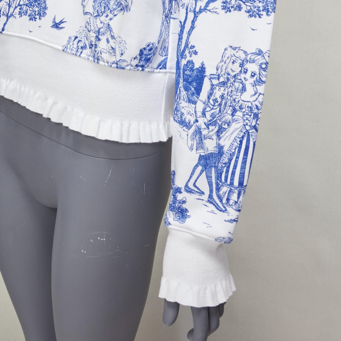 MOSCHINO Anime Toile De Jouy blue white frill trim hoodie sweater IT36 XXS
Reference: AAWC/A01110
Brand: Moschino
Designer: Jeremy Scott
Material: Cotton
Color: White, Blue
Pattern: Abstract
Closure: Pullover
Made in: Portugal

CONDITION:
Condition:
