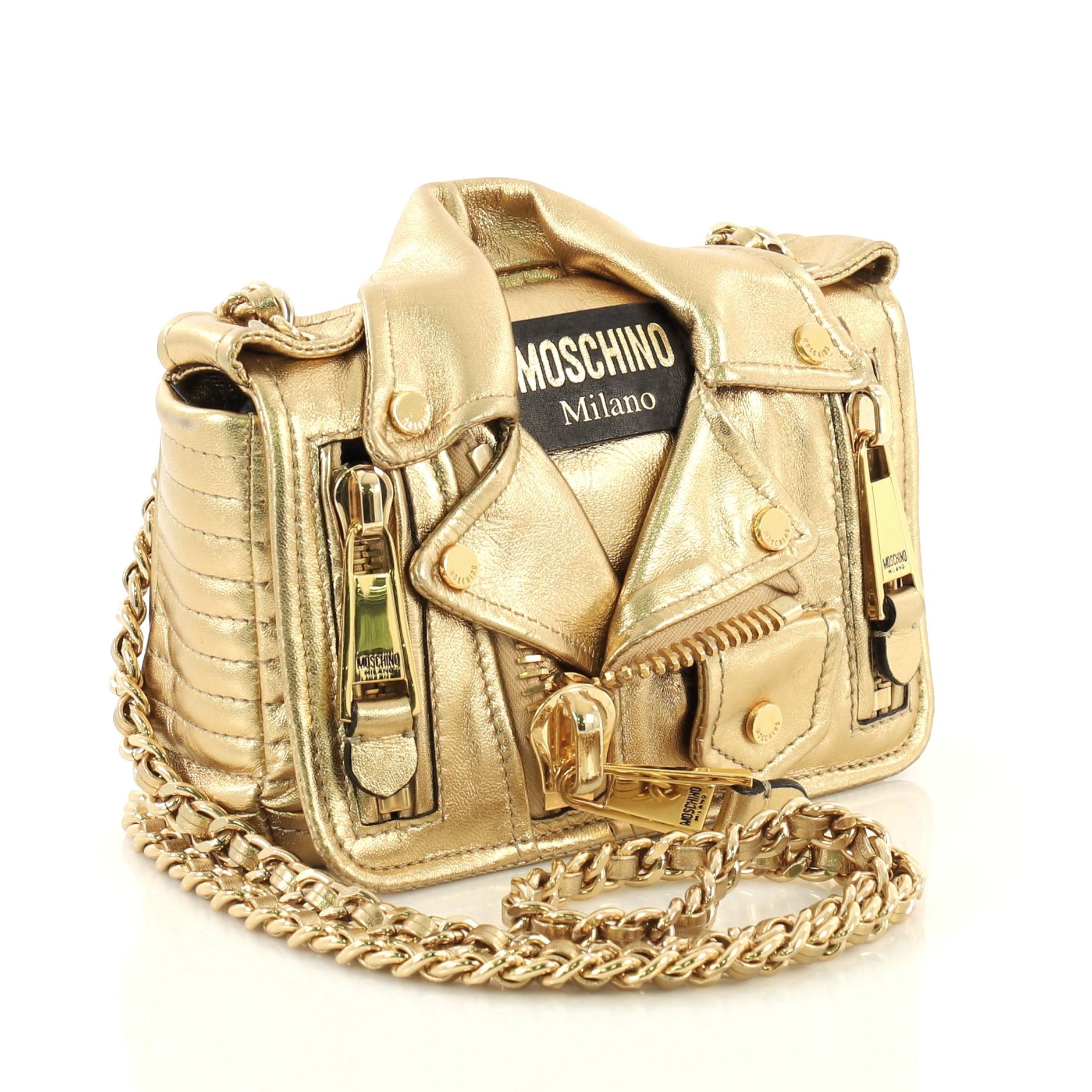 This Moschino Biker Bag Leather Small, crafted from gold leather, features woven-in leather chain strap, exterior zip pockets, and gold-tone hardware. It opens to a black fabric interior with slip pocket. 

Estimated Retail Price: $1,995
Condition: