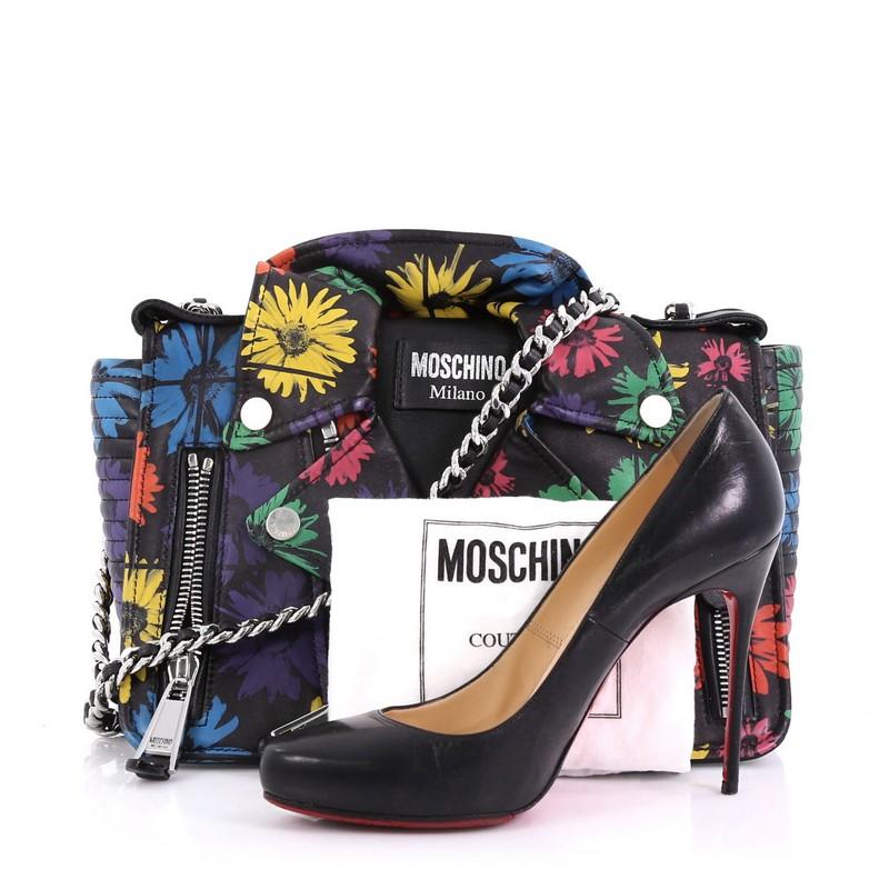 This Moschino Biker Bag Printed Leather Medium, crafted from embroidered black printed leather, features woven-in leather chain strap, exterior zip pockets, floral print, and silver-tone hardware. Its flap opens to a black fabric interior with zip