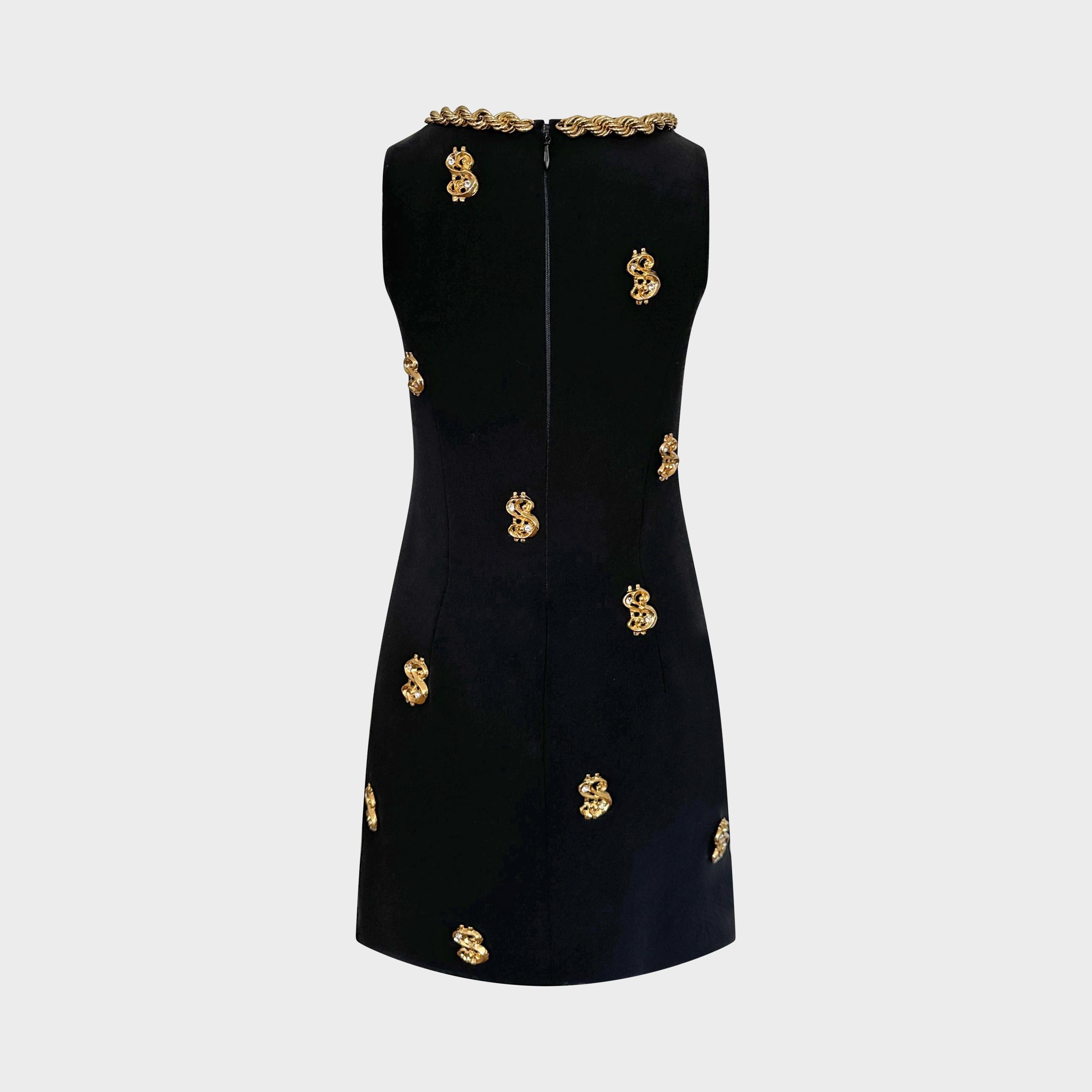 Issue de la collection automne/hiver 2019 de Moschino par Jeremy Scott, cette robe en crêpe noir incarne le mélange de satire et d'artisanat couture propre au créateur. La silhouette trapézoïdale structurée est richement brodée de signes de dollars