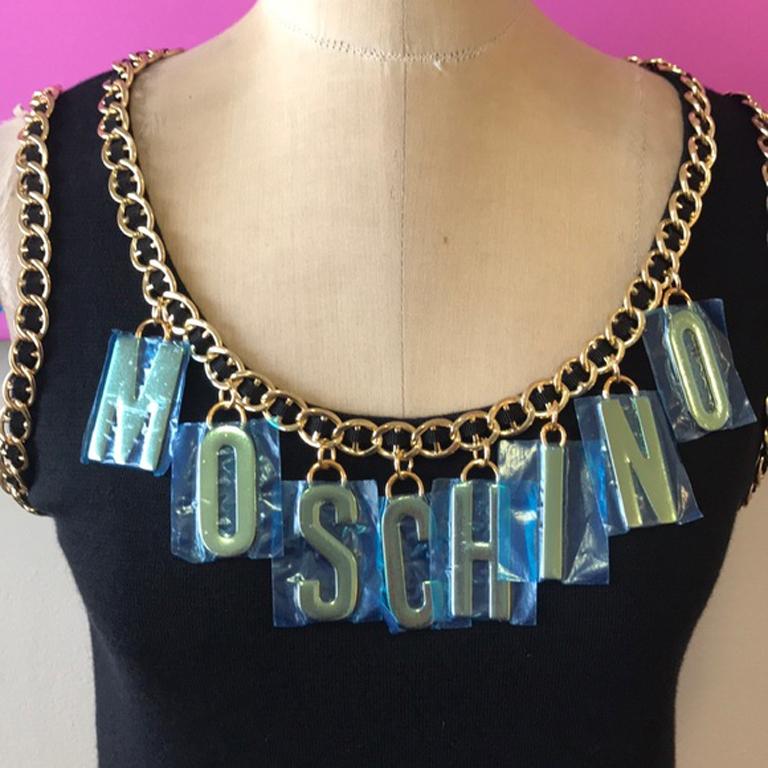 Moschino, maglione con catena d'oro nera e lettera di charm nwt

Moschino è più sexy che mai con Jeremy Scott al timone e anche tu puoi essere alla moda indossando questo top! Non è mai stato indossato ed è tutto in metallo. Le lettere hanno ancora