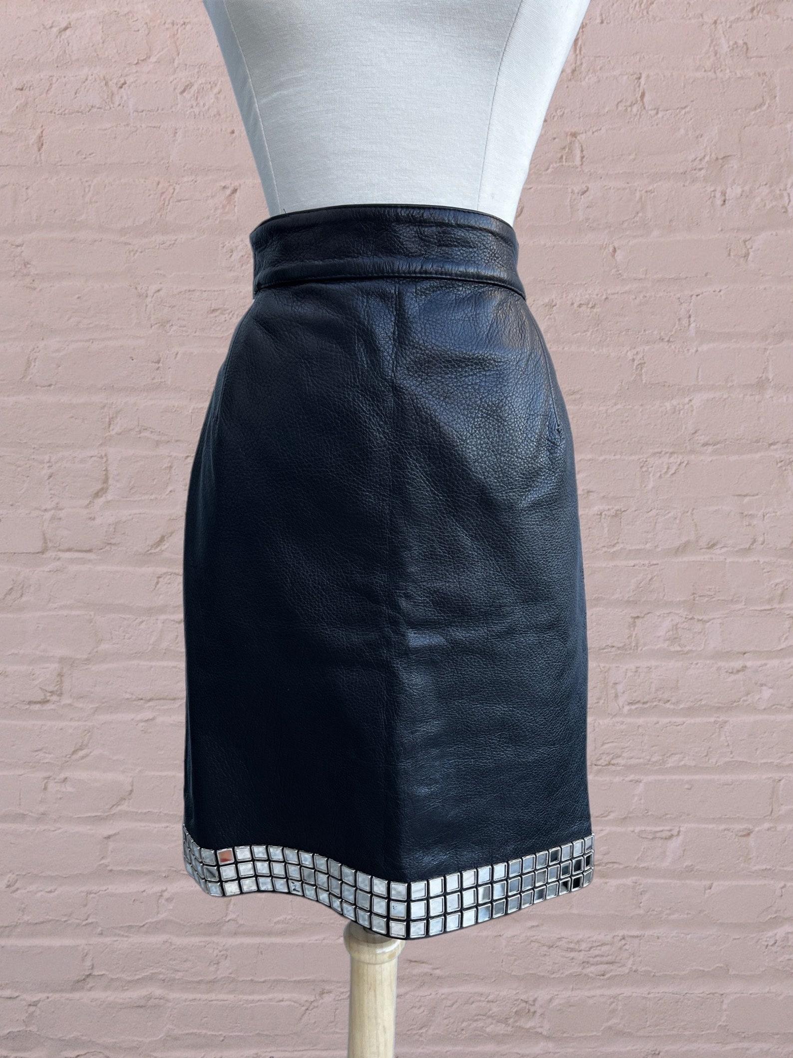 Moschino pebbled leather skirt. 
High waist. Pencil silhouette. 
Small mirror tiles around the hem. 
Back zip closure with snap button at waist.

✩ This skirt is an amazing and rare find!

Circa Spring/Summer 1990
Moschino 
Made in Italy
100%