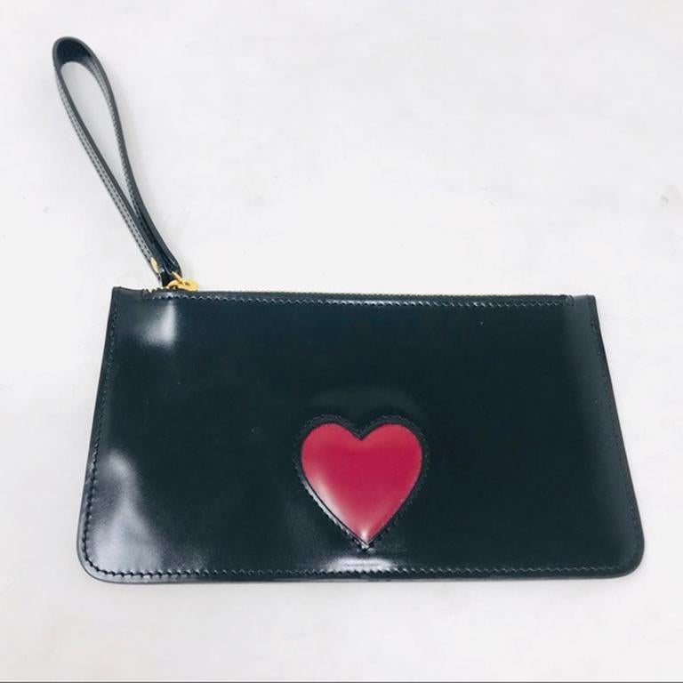 Moschino black leather red heart wristlet clutch

This adorable wristlet is perfect for adding some fun on your night out! Small but potentially large enough for your cell phone! Check measurements. Light surface scratches throughout. Clean in side.