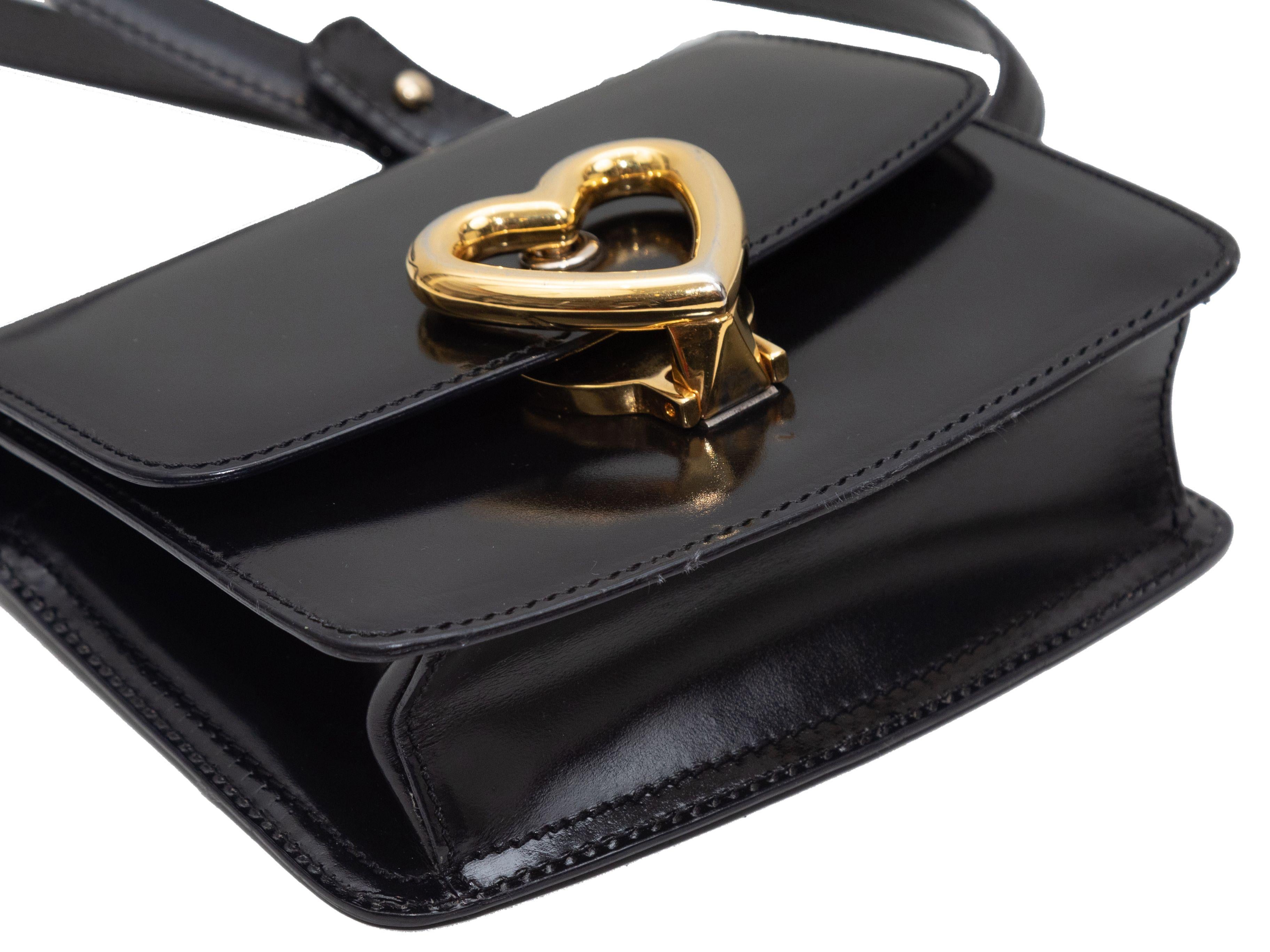 Produkt-Details: Schwarze Moschino Mini Patent Crossbody Bag. Diese Crossbody-Tasche hat einen Lederkörper, goldfarbene Beschläge, einen einzelnen flachen Schulterriemen und einen Herzverschluss vorne. 6