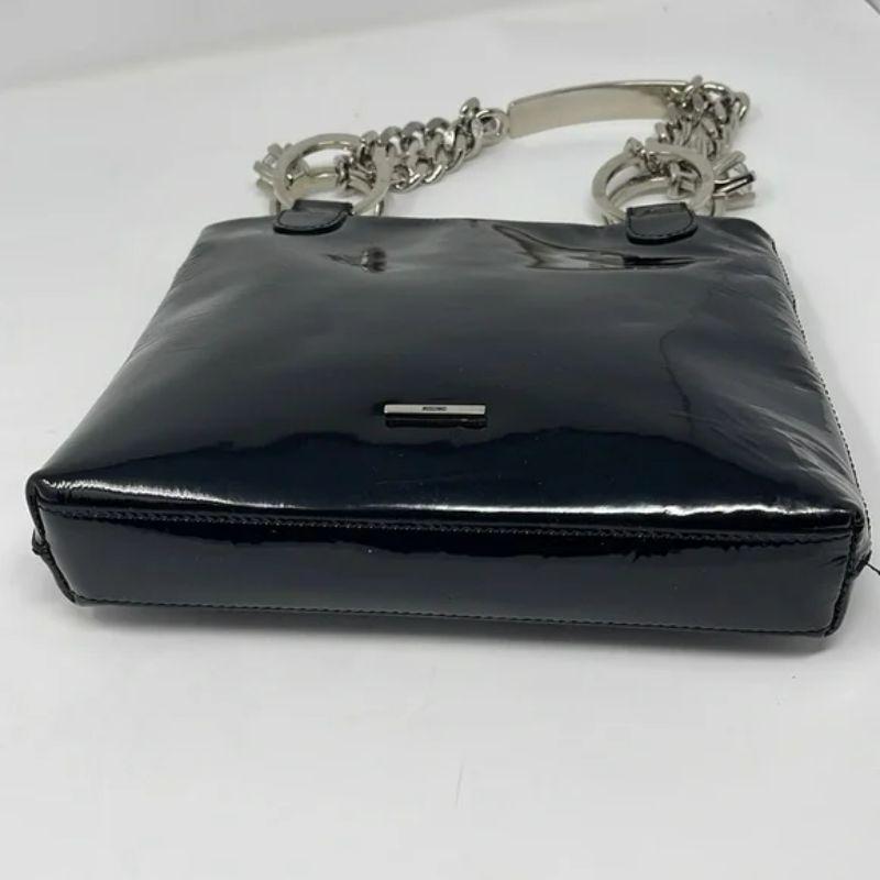 Moschino black patent leather wedding ring chain bag

Special occasion dressing shines with unique bags like this vintage one by Moschino, featuring a thick silver chain and handle with wedding rights / diamond rings on each side. 
NOTE: the chain