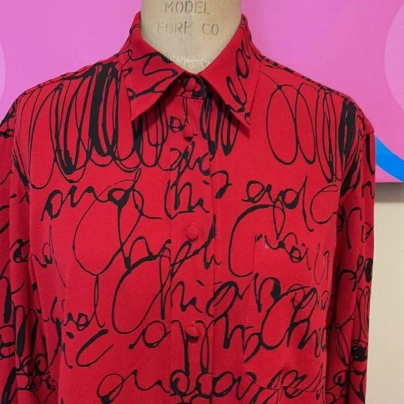 Moschino black red long sleeve blouse

Be retro cool wearing this vintage shirt by Moschino! Unique script pattern. Pair with black jeans and boots for a finished look. 
Size 8
Across chest - 20 1/2 in.
Across waist - 19 1/2 in.
Shoulder to hem - 26