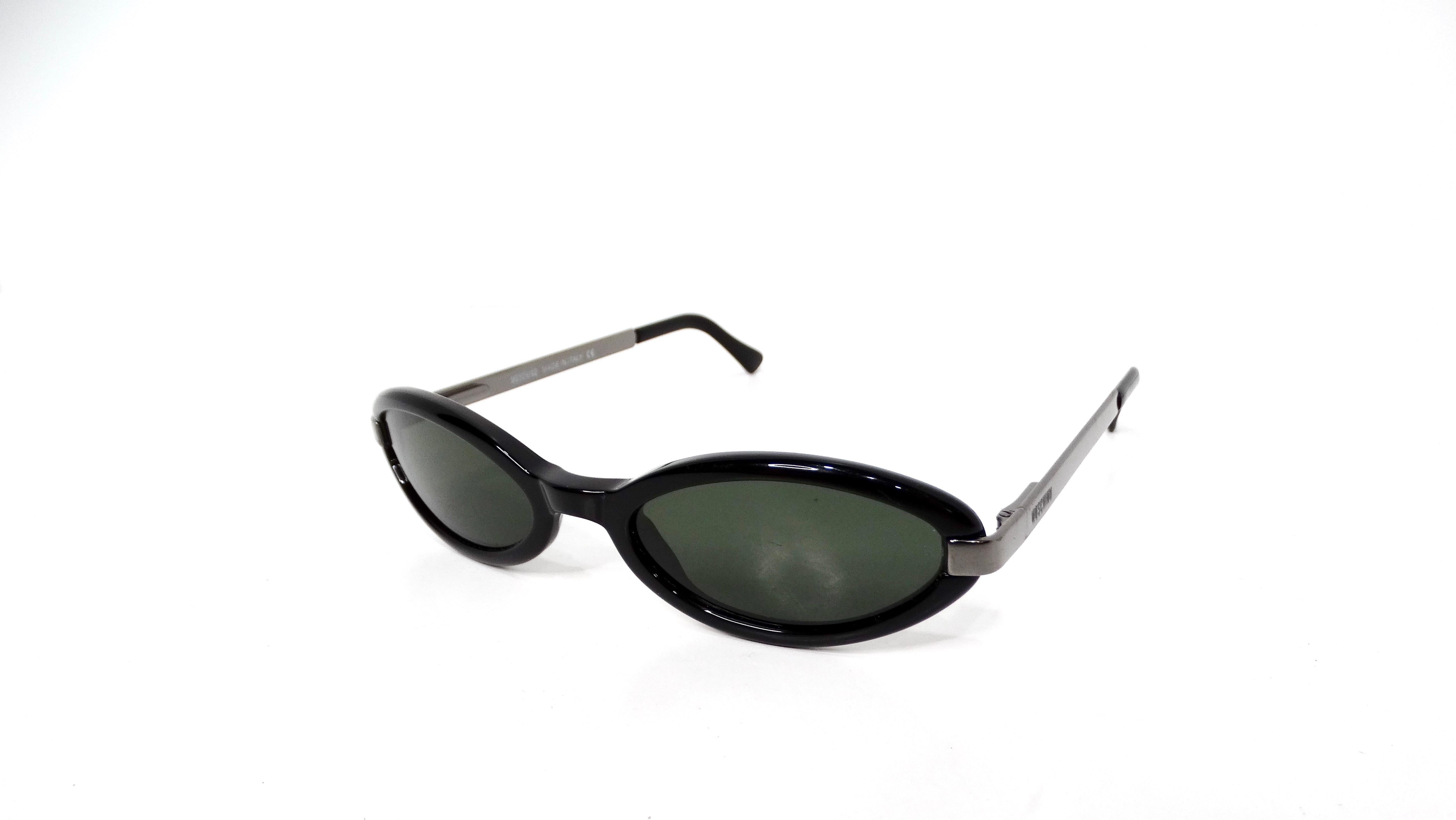 The Vintage Moschino Black Sleek Oval Sunglasses are a timeless accessory that exudes sophistication and retro charm. Crafted with a glossy black acetate frame, these sunglasses feature an elegant oval shape that complements a variety of face