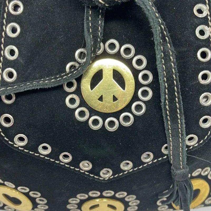 Moschino black suede draw string bag grommets hearts peace sign

Vintage Moschino is always an interesting find. This black suede draw string bag is a great example of their fun style that stand the test of time. Made of black suede with removable