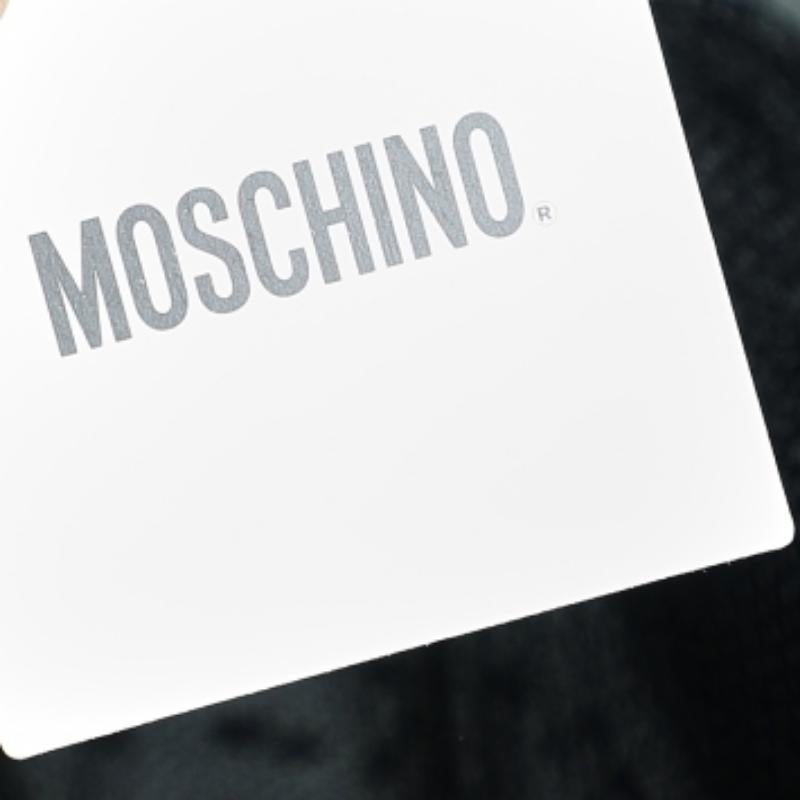 Crafted gracefully, this chic dress from Moschino is sure to grab everyone's attention. It has been tailored skillfully using black tulle and exhibits a ruffled hem, bow detail on the front, and sheer style. This mini dress is truly the epitome of