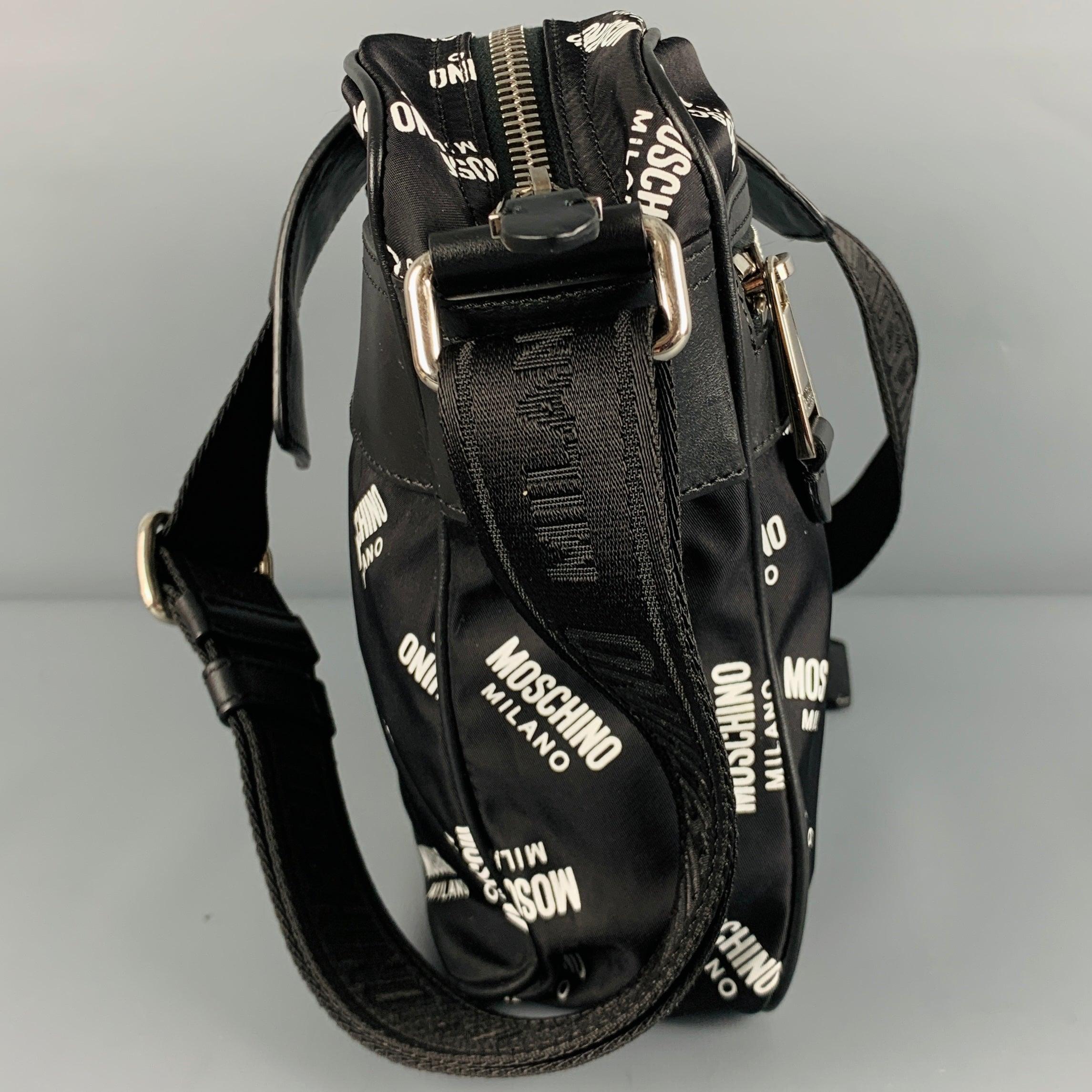 MOSCHINO bag
in a black nyln fabric featuring white logo pattern, crossbody style with wide adjustable shoulder strap, and zip closure. Made in Italy.Excellent Pre-Owned Condition. 

Measurements: 
  Length: 7 inches Width: 3.5 inches Height: 8
