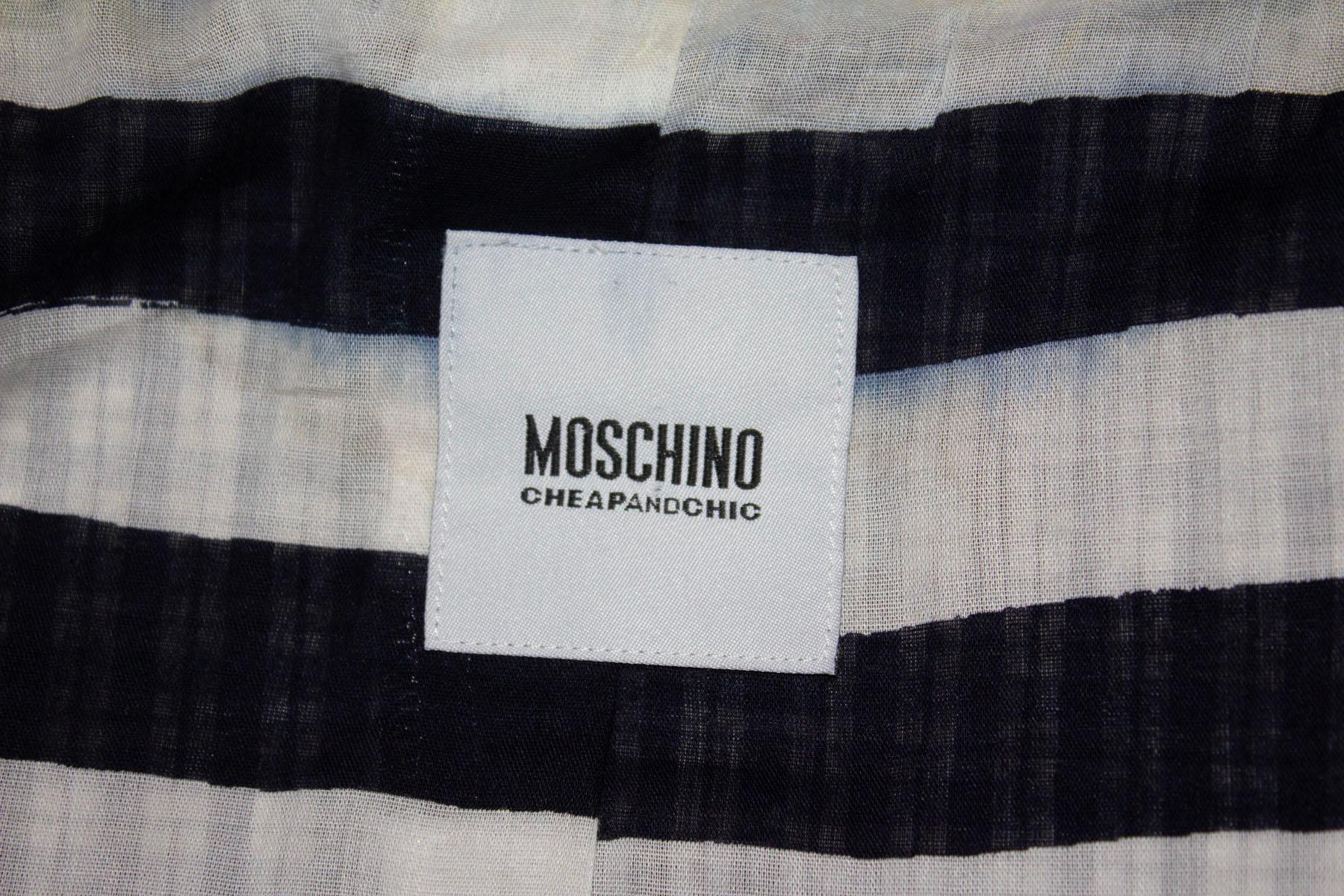 A fun jacket for Summer by Moschino . In a blue and white cotton seersucker, the jacket has an attractive collar and fun stripe lining.  It has a three button from opening, and peplum/frill detail at the lower front. 
Measurements: Bust up to 38'',