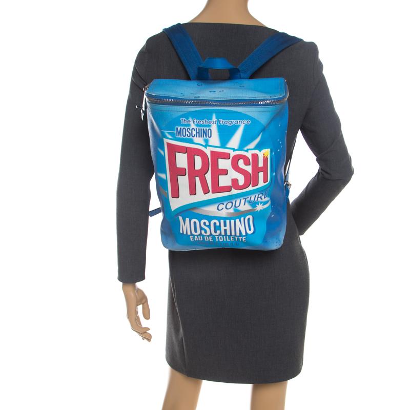 From Moschino Fresh Couture Spring '16, this blue backpack with 'Moschino Eau de Toilette' slogan is designed under the creative direction of Jeremy Scott. Secured by the two-way zipper, it is crafted from PVC and proportioned to fit your everyday