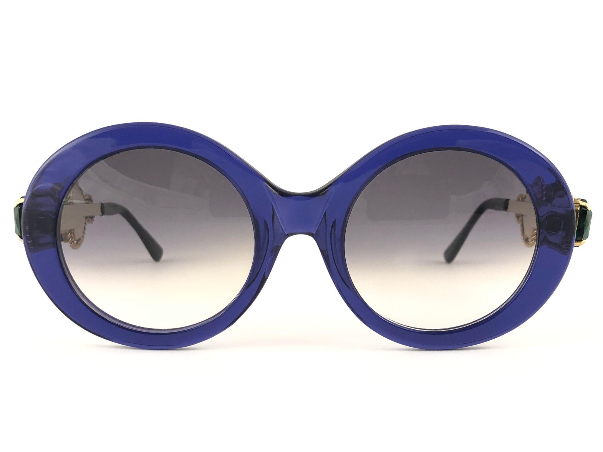 Rare Vintage Moschino oval with jewell details frame. Grey lenses.
The very same model worn by Lady Gaga.

Made in Italy.

FRONT : 13.5 CMS

LENS HEIGHT : 4.6 CMS

LENS WIDTH : 4.8 CMS

This item show minor wear on the frame due to storage.