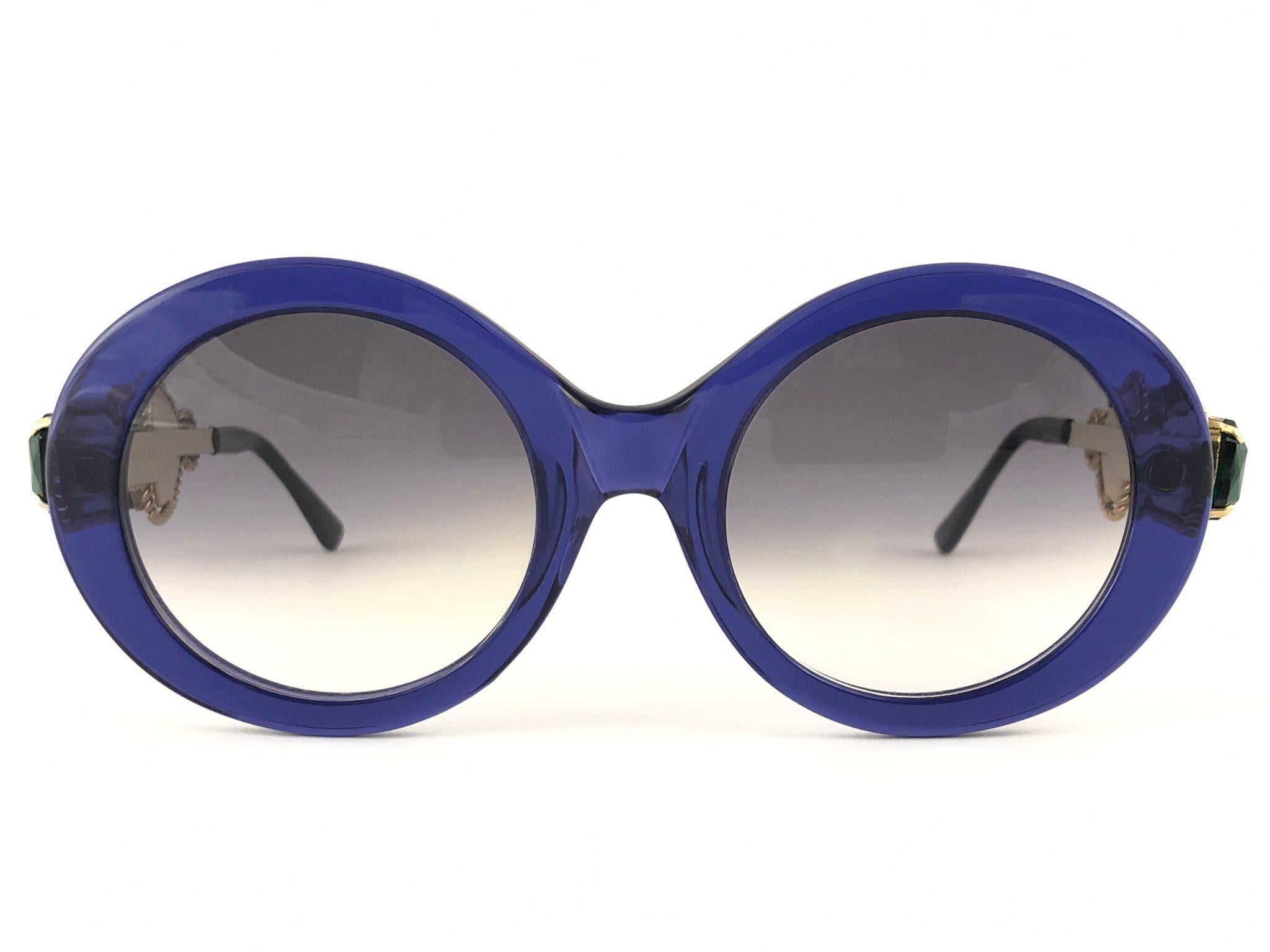 Rara cornice vintage Moschino ovale con dettagli gioiello. Lenti grigie.
Lo stesso modello indossato da Lady Gaga.

Prodotto in Italia.

ANTERIORE : 13.5 CMS

ALTEZZA DELLA LENTE: 4.6 CM

LARGHEZZA LENTE : 4.8 CMS

Questo articolo presenta lievi