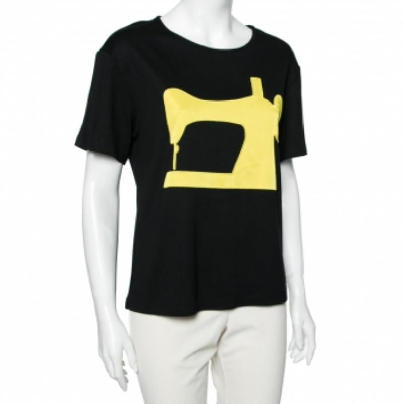 Redefine tu estilo informal con esta elegante camiseta de Moschino Cheap and Chic. Está confeccionado con tejido de punto negro, realzado con un estampado de Máquina de Coser en la parte delantera. Tiene mangas cortas. Esta camiseta puede combinarse