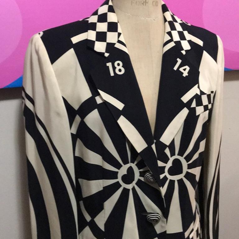 Moschino cheap chic bullseye blazer

Stand out in the right way wearing this bullseye blazer in cream and black! Unique spiral buttons with braided rope. Pair with black skinny pants or pencil skirt or a finished look.
Size 8
Across chest - 19.5