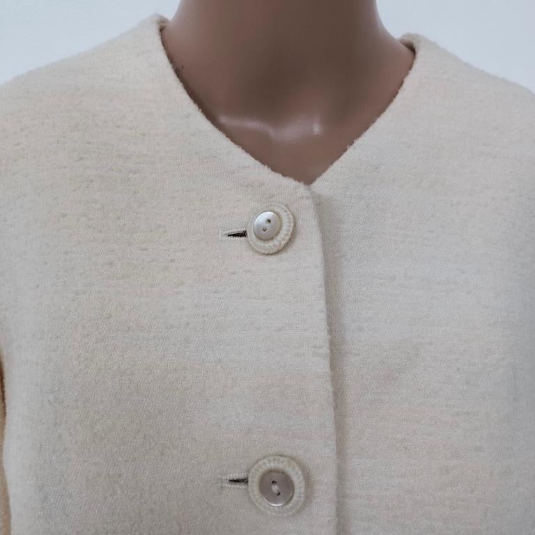 Moschino Cheap and Chic collarless jacket in a warm-cream bouclé wool blend, produced in the mid-1990s. The tight bouclé weave has a subtle nubby texture reminiscent of raw silk; the soft ivory tone flatters most complexions and pairs easily with