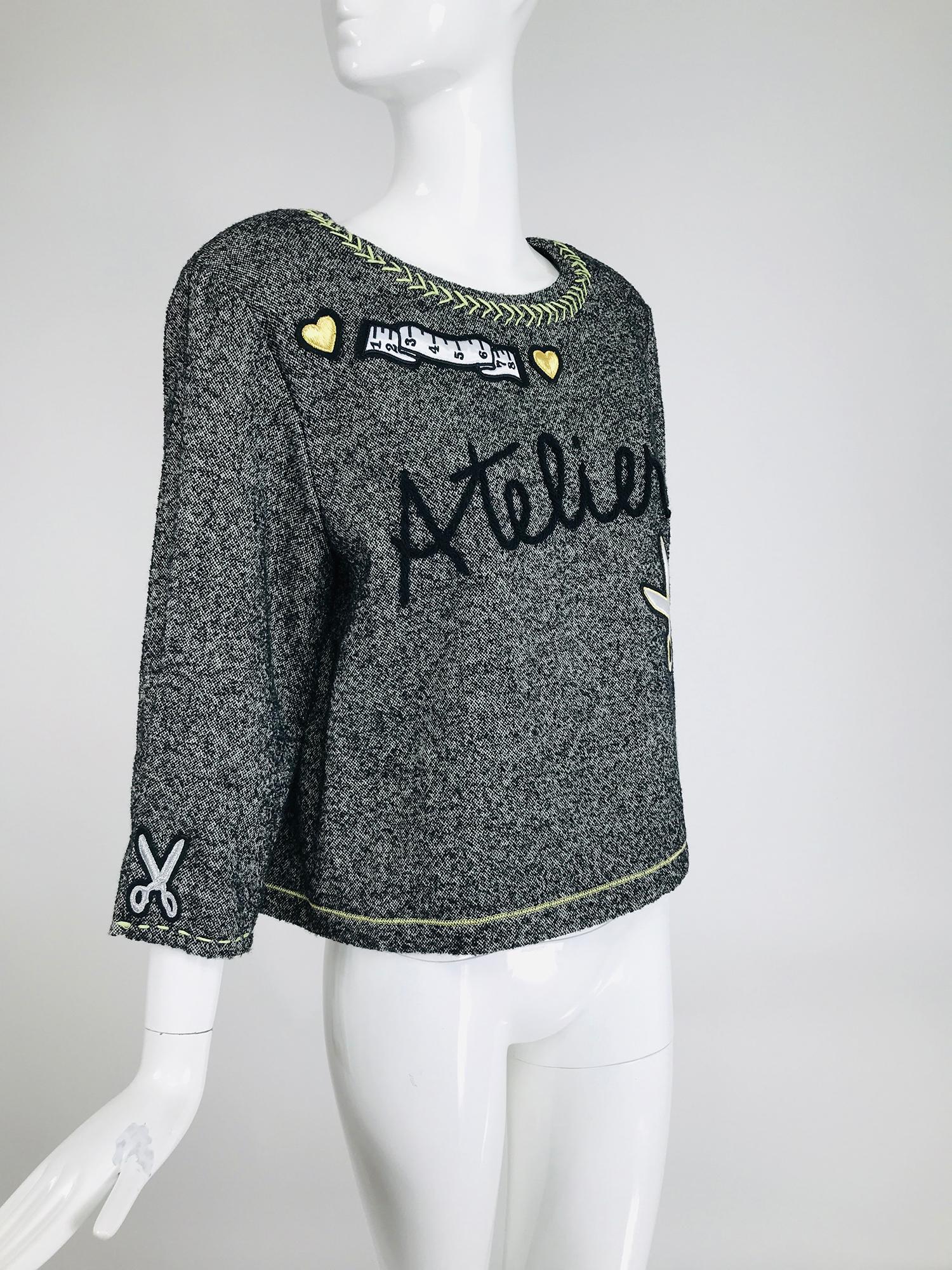 Moschino Cheap & Chic Atelier! tweed applique top 2015. Black & grey tweed, long sleeve pull on top is appliqued with hearts, scissors & tape measures, embroidered at the front with Atelier!. Fully lined in black acetate. Closes at the upper back