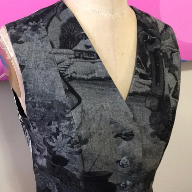 Moschino cheap chic gray wool vest vintage

Unique wool vest with print of houses and flowers and horse shoes ! Perfect for Fall with black wool skinny pants and boots over a long sleeve white blouse
Size 6
Across chest - 16 1/2 in.
Across waist -