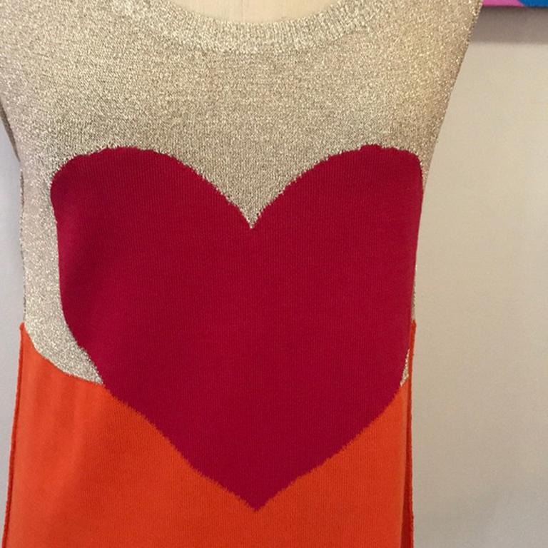 Moschino cheap chic orange red gold heart sweater

Be retro cool in this vintage sweater tank by Moschino Cheap and Chic with iconic heat design. Cotton knit with some metallic thread.
Size 6

Across chest, armpit to armpit - 15.5 inches laying