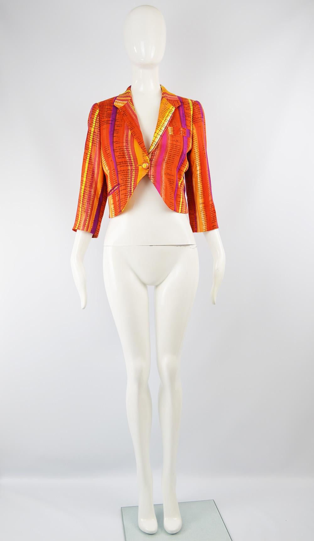 A bold and fun vintage women's cropped jacket from the 90s by Moschino for the Cheap and Chic line. In a rayon fabric that is woven in a way that it feels like linen and has watercolor inspired stripes in hues of oranges, purples, reds and white to