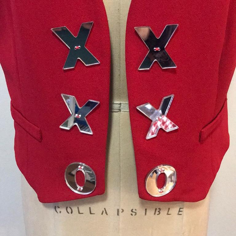 Moschino cheap chic red cut out heart vest vintage

This unique vintage vest / waist coat by Moschino has many nice elements like XO mirror buttons and a heart cut out in the back. Pair with black skinny pants and boots with a ruffle front long