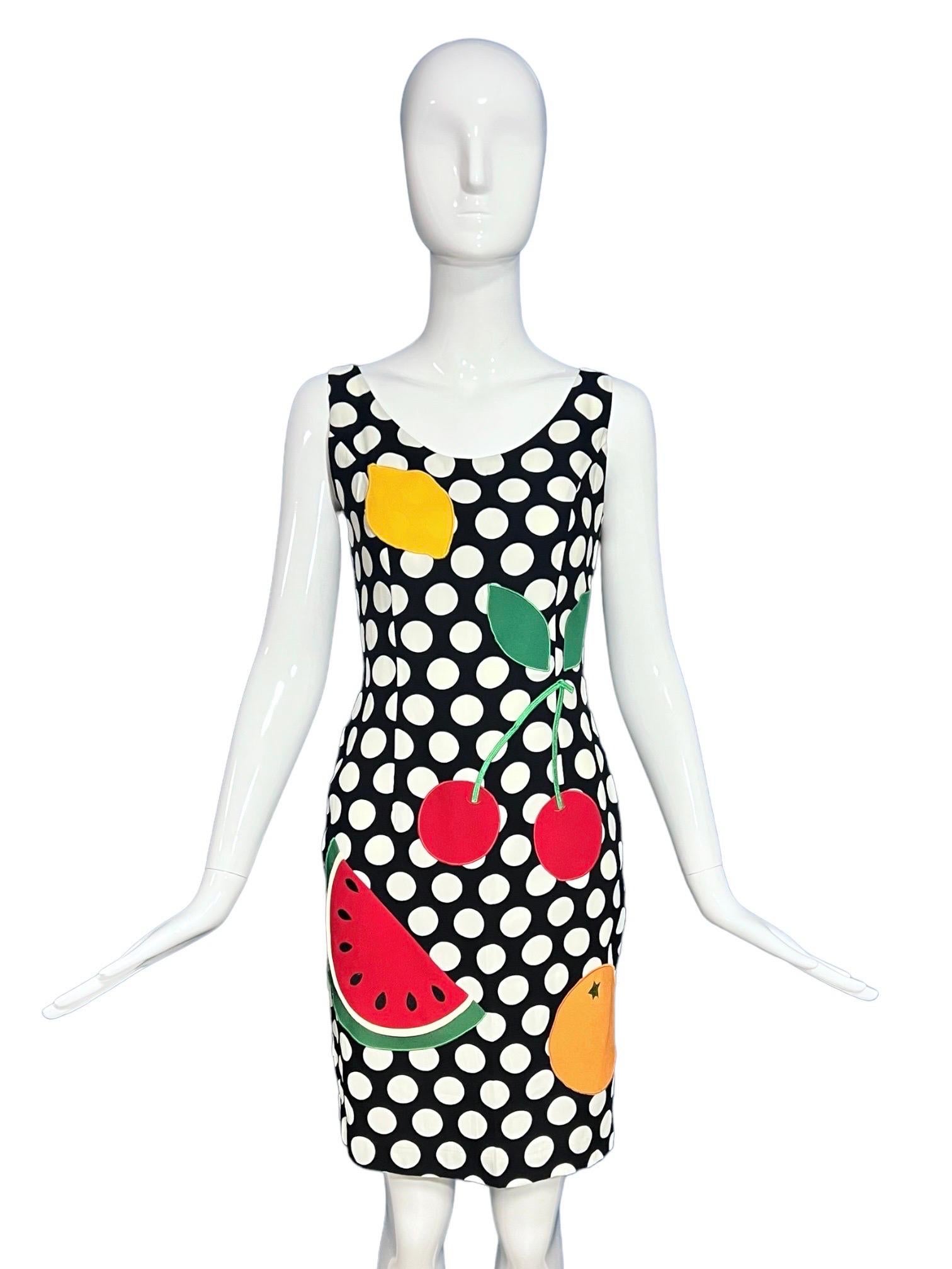 Highly collectable and iconic 1990's polka dot fruit appliqué dress by Moschino Cheap & Chic as seen on Fran Dresher in The Nanny.
This iconic Moschino dress from the 1990s is made of a lightweight crêpe fabric with white polka dots against a black