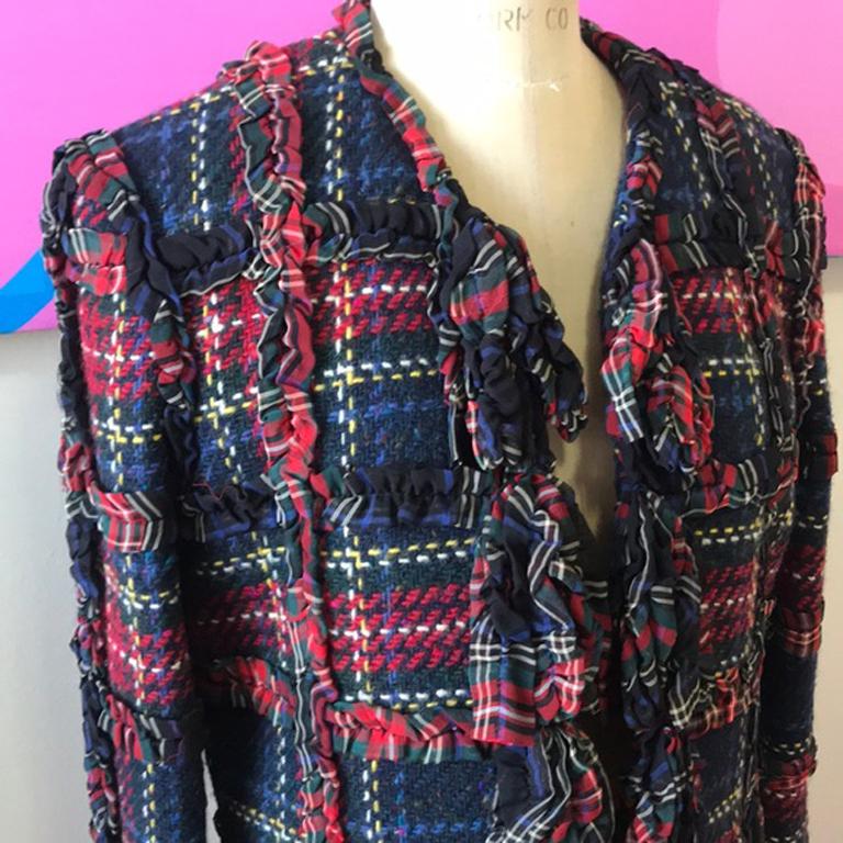 Moschino billig chic Wolle karierten Rüschen Jacke

Die perfekte Herbstjacke mit einzigartiger, kleiner Riffelborte, die eine karierte Jacke mit Bändchenfransen umrandet, ist da. Dieser kastenförmige Stil wird ein Klassiker sein und lässt sich