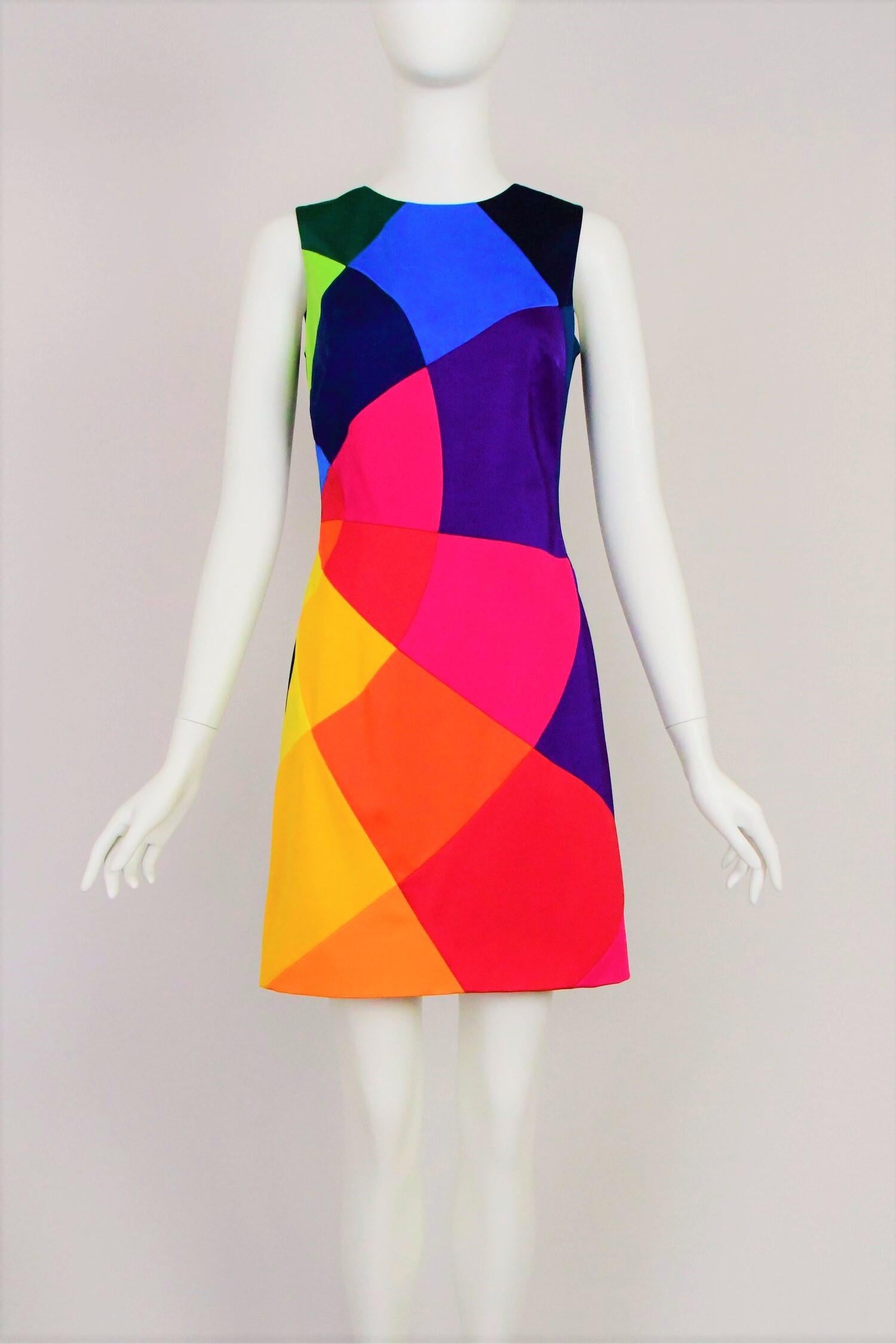 A fabulous colourful dress with a bit of stretch from Moschino. It is is sleeveless with a crew neck and incredible brightly coloured shapes each individually sewn together comprising the front of the dress, the back is solid black. It is lined in