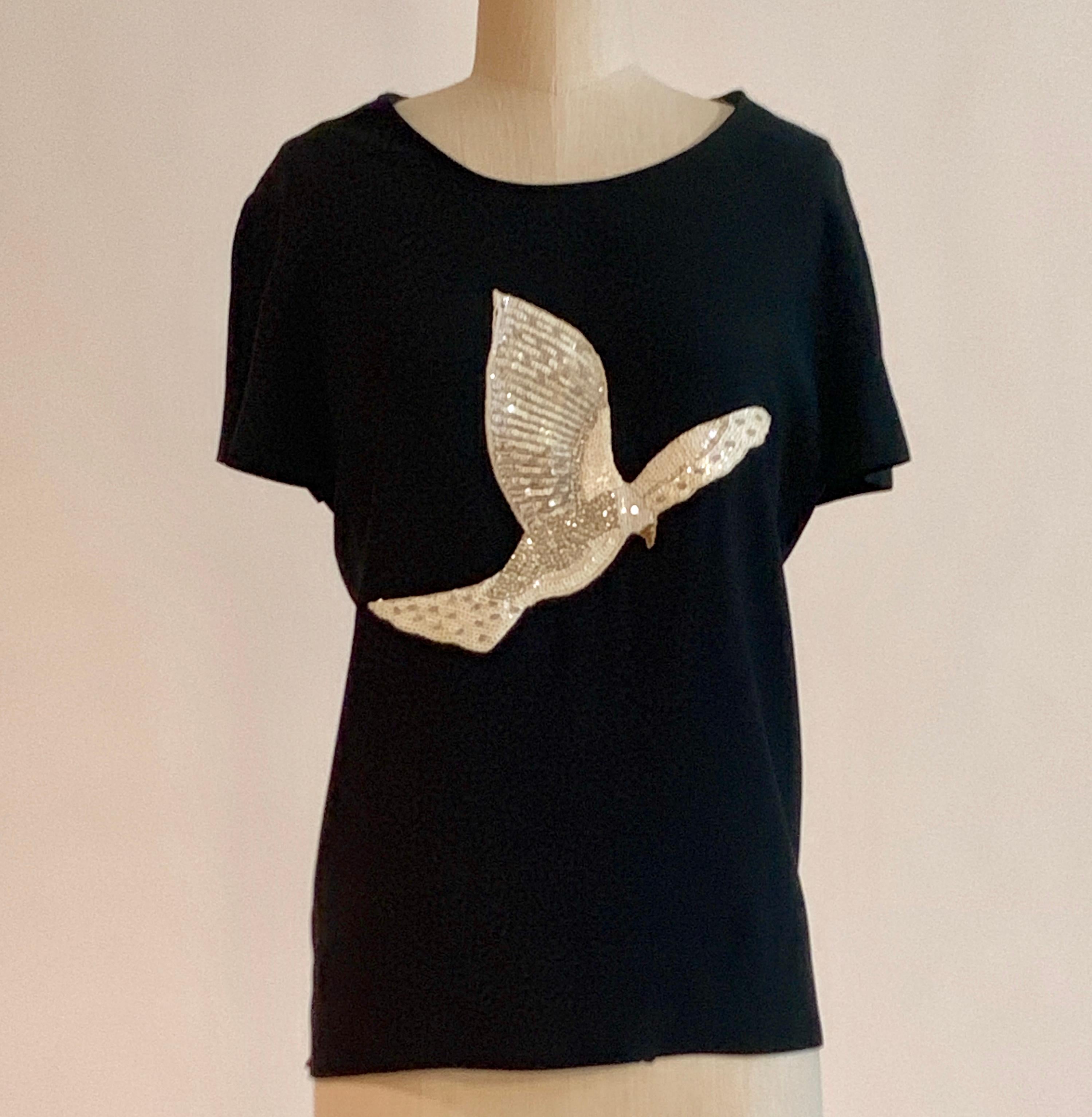 Vintage Moschino Couture 1980s dark navy (almost black) short sleeve blouse with cream, white, silver and gold sequin and bead dove at front.  Pull on style with no closures. 

55% acetate, 45% rayon.

Made in Italy.

Labelled size IT 44, US 10.