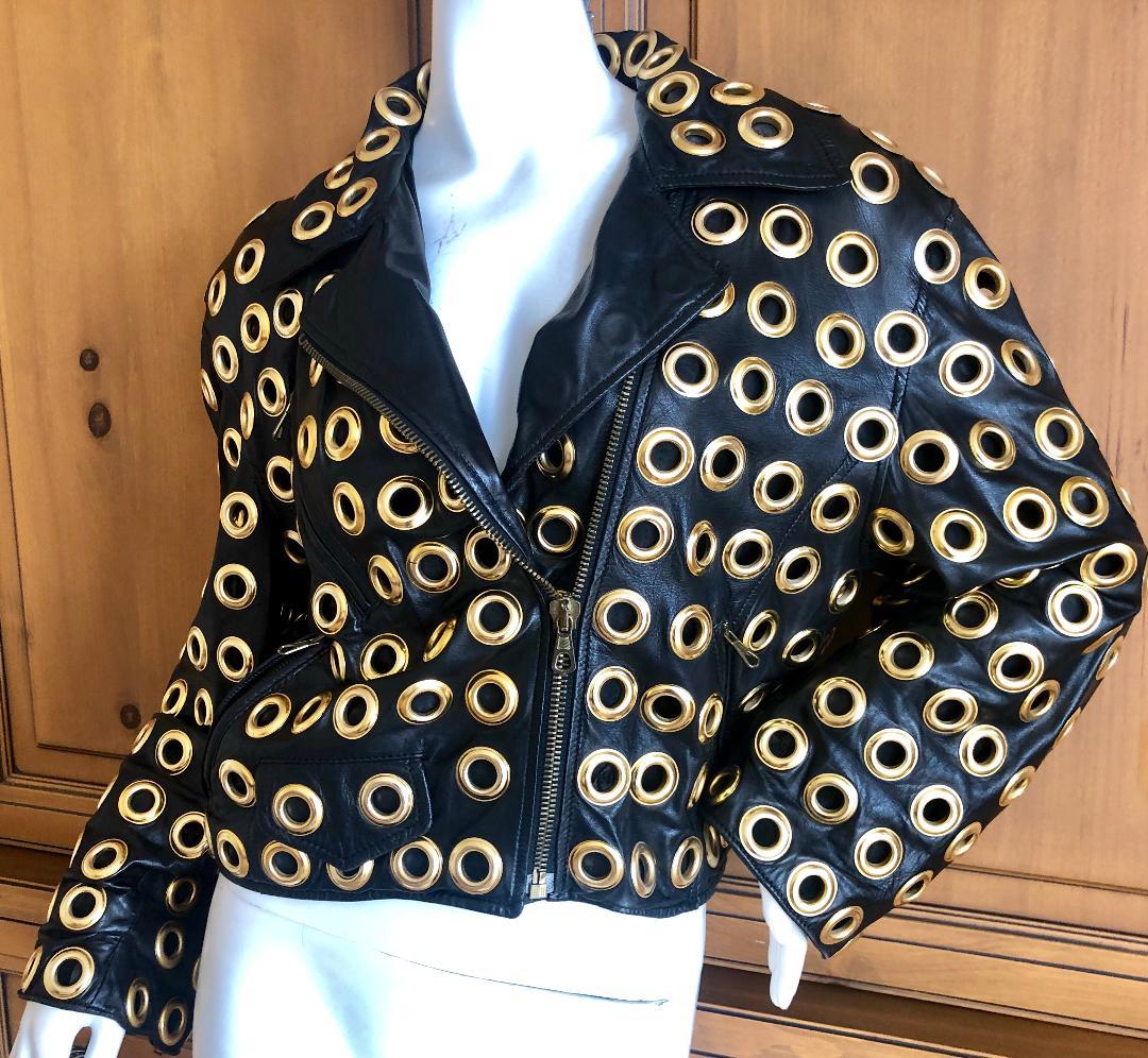 Moschino Couture 1980's Leather Moto Jacket with Bold Grommet Details.
So wonderful, this is lined , so the grommets are not see through.
Weighs a lot, the brass is heavy.
No size tag, this is  Large, and will also fit a small man.
Bust 40