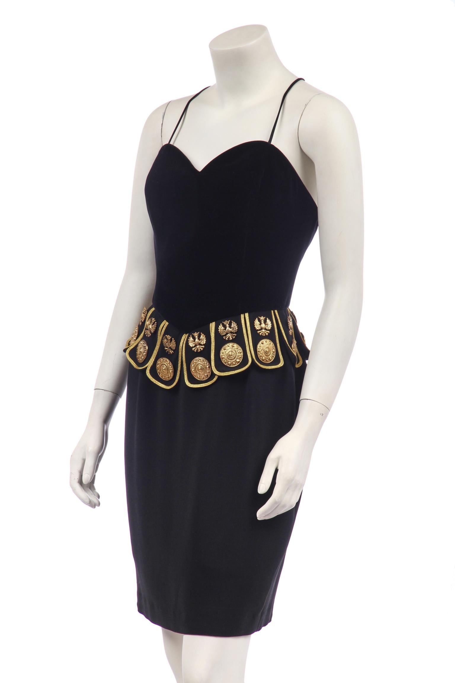 - Moschino Couture
- Robe gladiateur
- De la collection S de 1989
- Corsage ajusté en velours noir sur jupe en crêpe noir
- Pattes de serrage à la taille, bordées d'or et de métal complexe. 
  médaillons et embellissements en forme d'aigle
- Mini