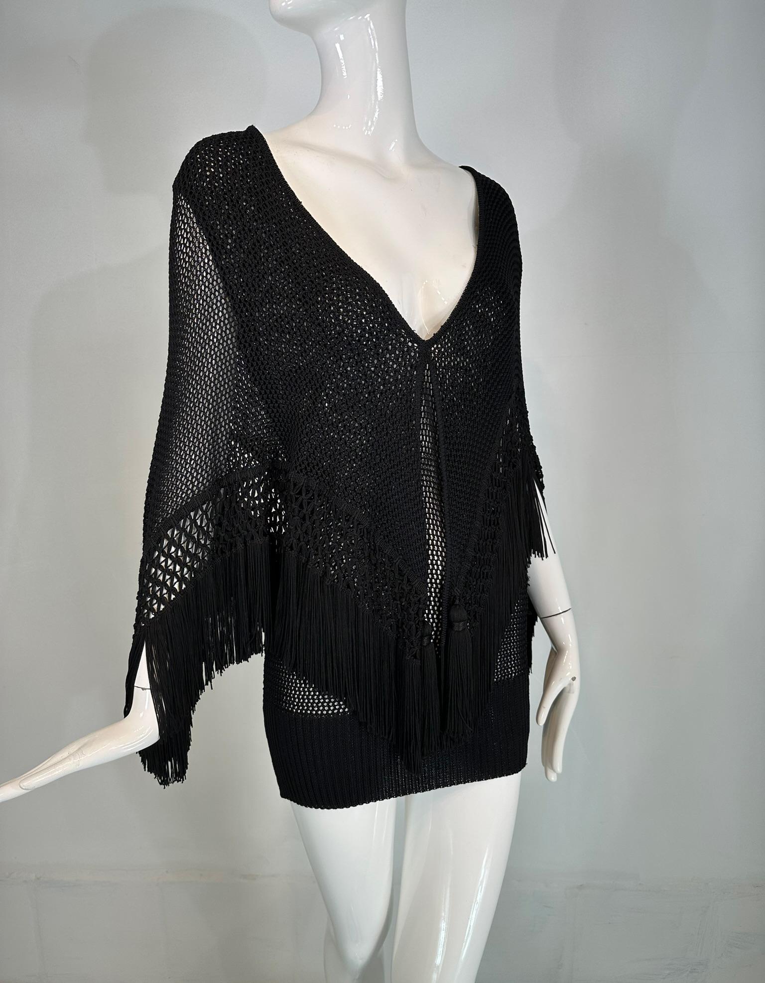Moschino Couture black crochet fringe cape, with tassels mini dress. Pull on sleeveless dress with a V neckline fitted through the body and ribbed hem. The cape is attached at the neck and falls over the arms, drapes to a point at the back & forms