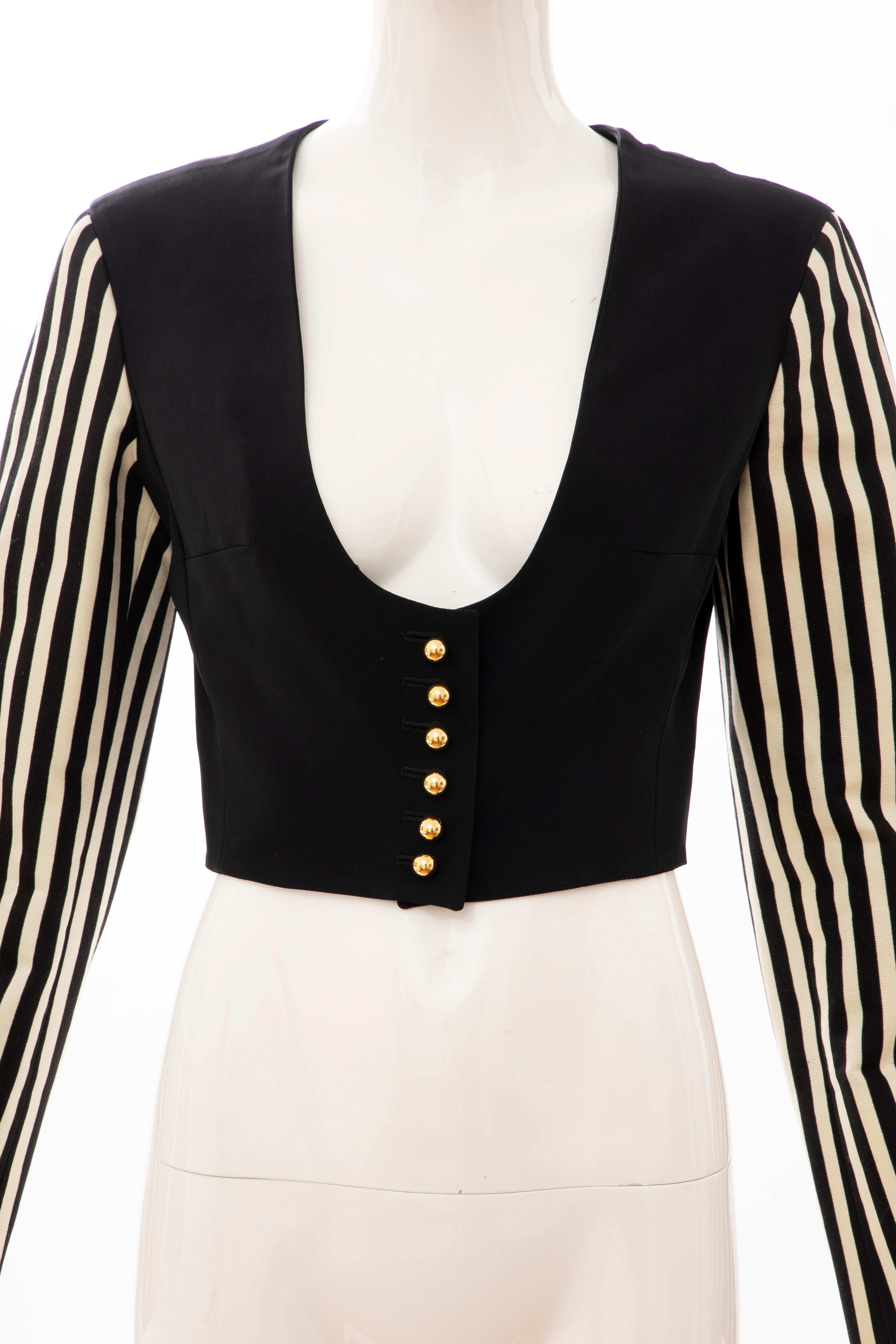 Moschino Couture, Circa: 1994 black cotton cropped brass button front jacket with acetate & rayon faille black & white striped sleeves and fully lined.

IT. 42, D. 38, FR. 38, GB. 10, US. 8

Bust: 35, Waist: 27, Shoulder: 15.5, Sleeve: 23.5, Length: