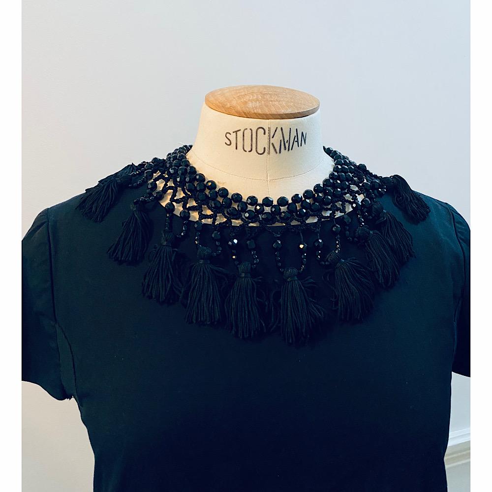 Impressive couture black vintage tassel collar made by Moschino in the 90s. Made of black crystal beads and passementerie. 

Marked: Moschino
Size: lenght from 40 to 45cm (15 3/4 to 17 3/4 L in),Width: 10 cm – 4 in
Condition: Excellent condition
