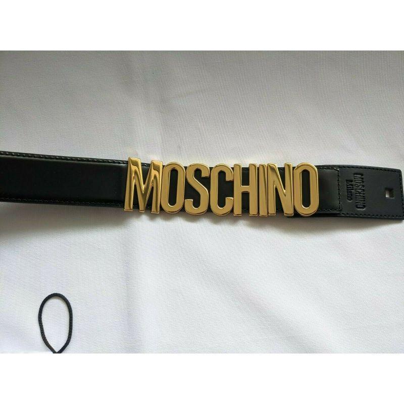 Moschino Couture Jeremy Scott Cinturón de piel negra brillante con logotipo en letras doradas en venta 1