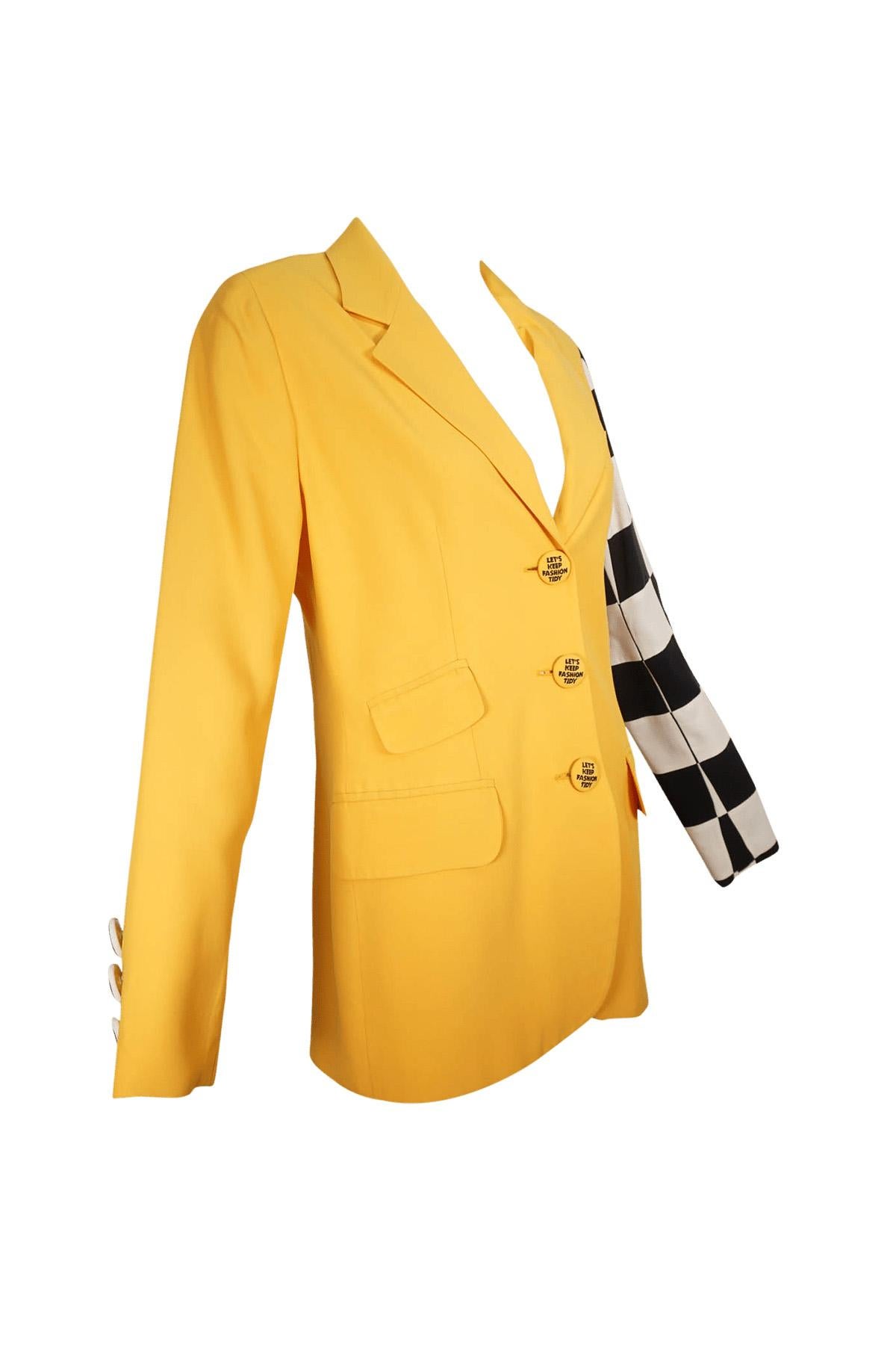 Americana vintage Moschino Couture de un solo pecho, de la colección de 1990, en amarillo taxi con una manga a cuadros blancos y negros. Esta chaqueta tiene un cierre delantero de tres botones, en cada uno de los cuales se lee 