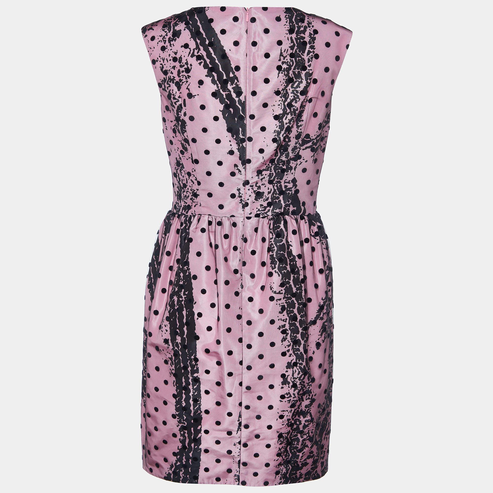 The Moschino Couture dress is a striking blend of elegance and playfulness. It features a satin sheath silhouette adorned with intricate prints, accented with polka dot tulle on all over for a whimsical touch, creating a chic and sophisticated