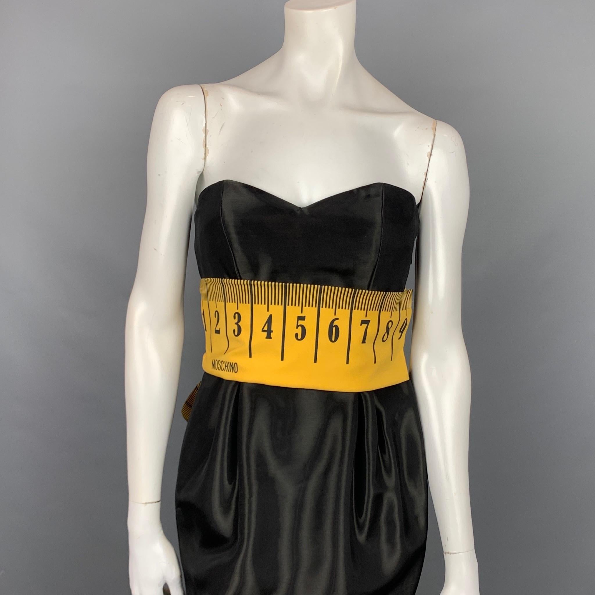 MOSCHINO COUTURE Pre-Fall 15 cocktail dress comes in a black rayon blend featuring a yellow tape measure bow design, sweetheart neckline, strapless, hook & loop, and a side zipper closure. Made in Italy.

New With Tags.
Marked: I 40 / D 36 / F 36 /