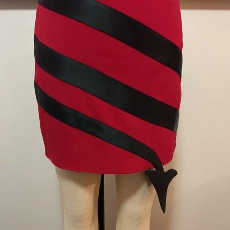 Moschino couture red black devil tail pencil skirt

Date night is super sexy wearing this devil's fork tail skirt! Pair with black turtleneck sweater, tights and boots for a finished look. This is a very rare piece in excellent condition.
Brand runs