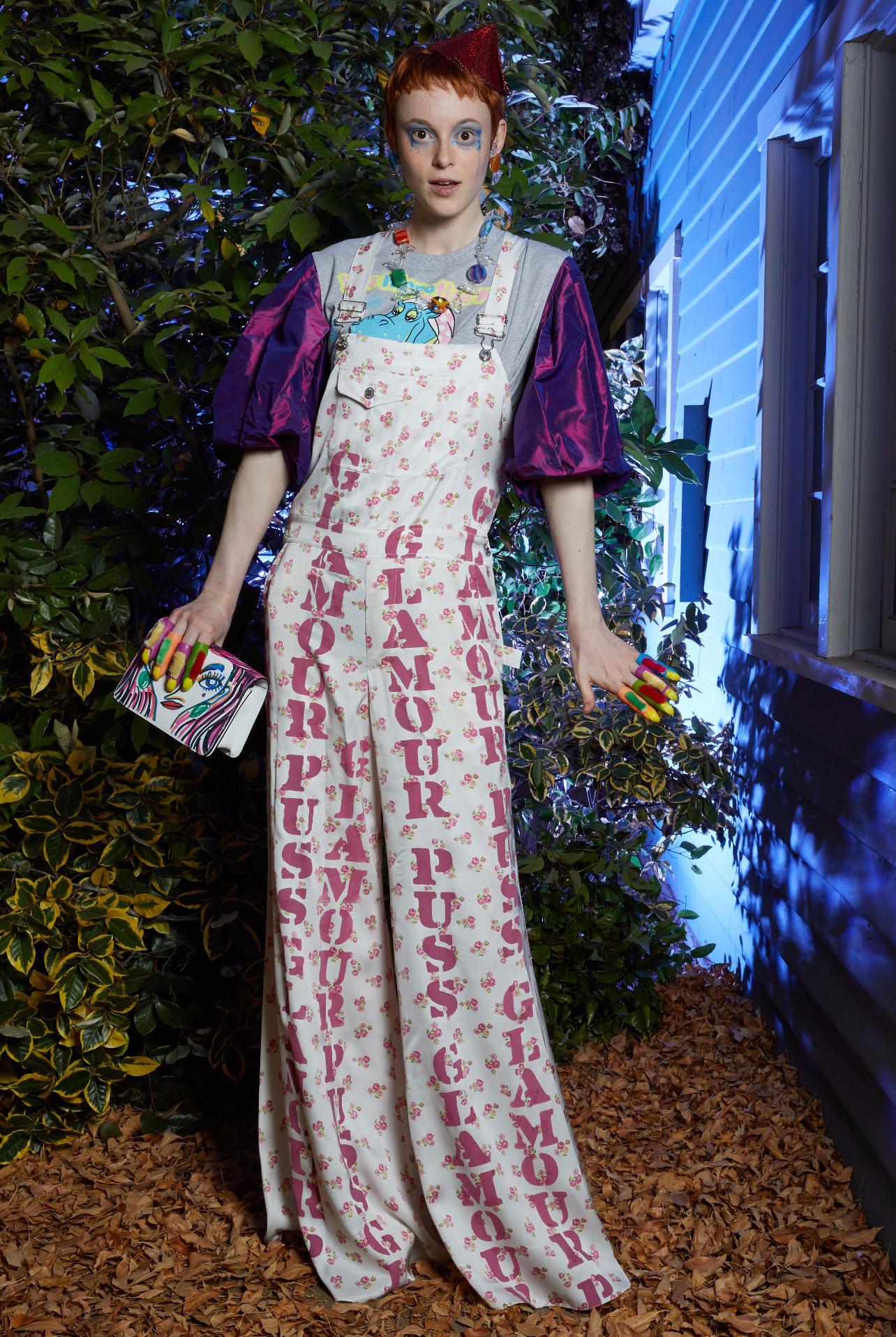 Amazing MOSCHINO COUTURE Resort 2020 
 ‘ GLAMOUR PUSS ‘ white and pink overalls / jumpsuit ! Carpenter 90s style with wide legs. Graffiti print down the front and back, amongst bouquets of flowers. Hidden zipper up the side, with hidden snaps.