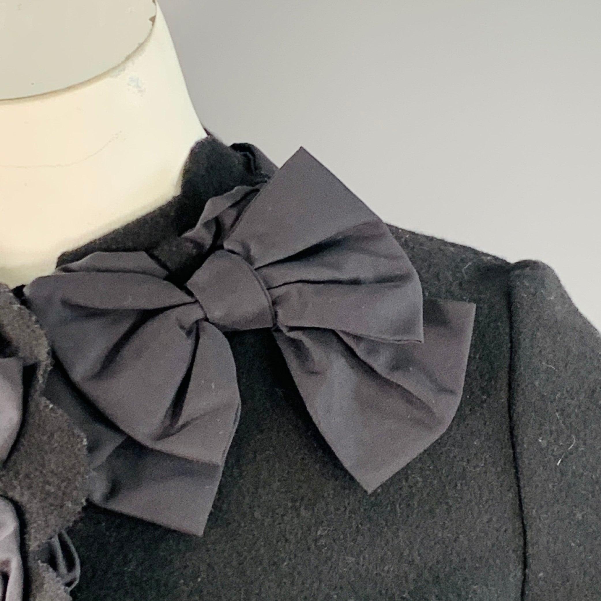 Blazer MOSCHINO COUTURE
en laine mélangée noire, avec une bordure festonnée et des rubans, un nœud et une fermeture à bouton-pression cachée. Fabriqué en Italie. Excellent état. 

Marqué :   IT 44 

Mesures : 
 
Épaule : 14.75 pouces Buste : 36