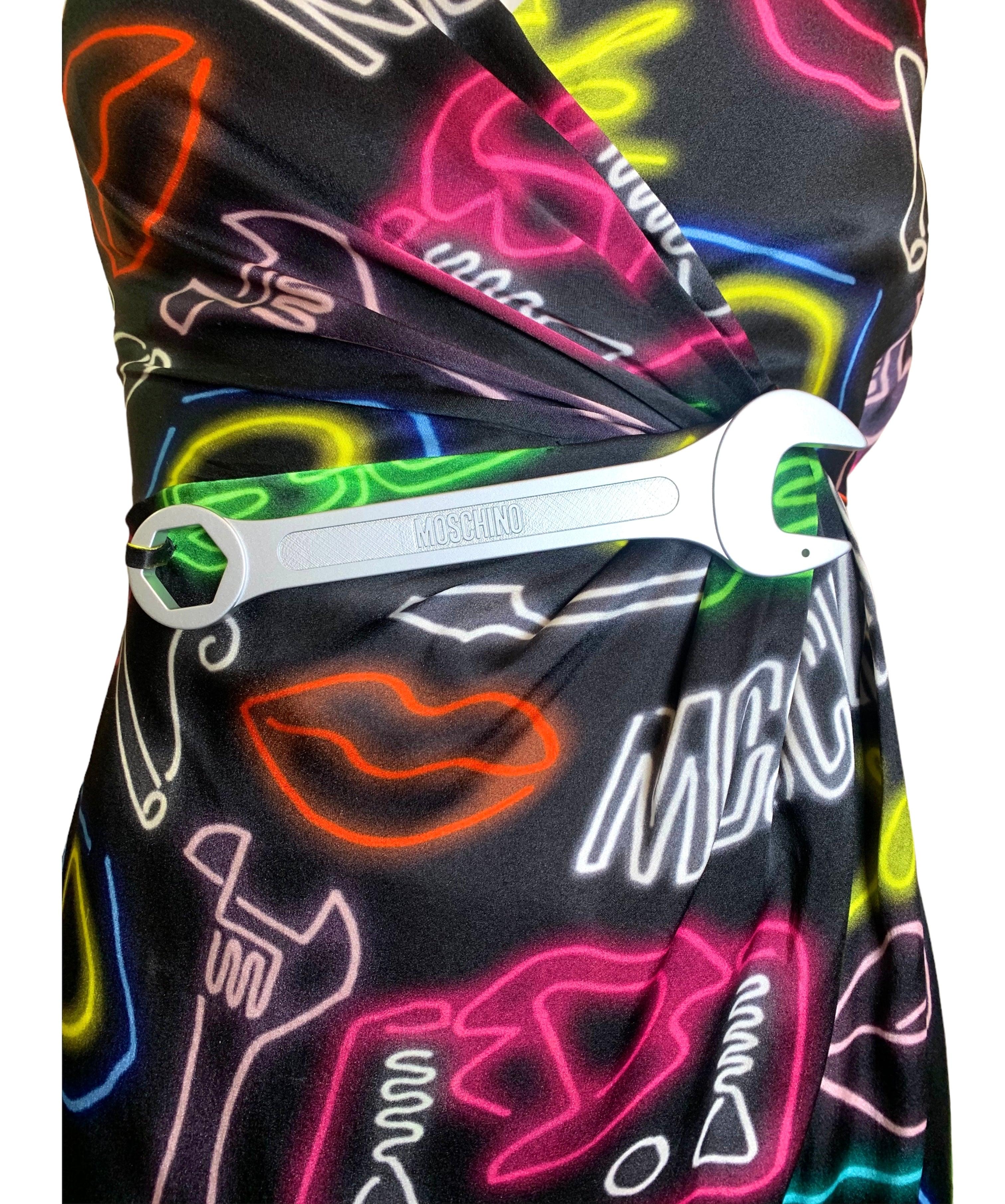 Disegnato da Jeremy Scott per la collezione Moschino Primavera/Estate 2016, questo abito accattivante è un vero capolavoro. Realizzato in lussuosa seta e caratterizzato da vivaci stampe neon, questo abito è allo stesso tempo elegante e comodo.