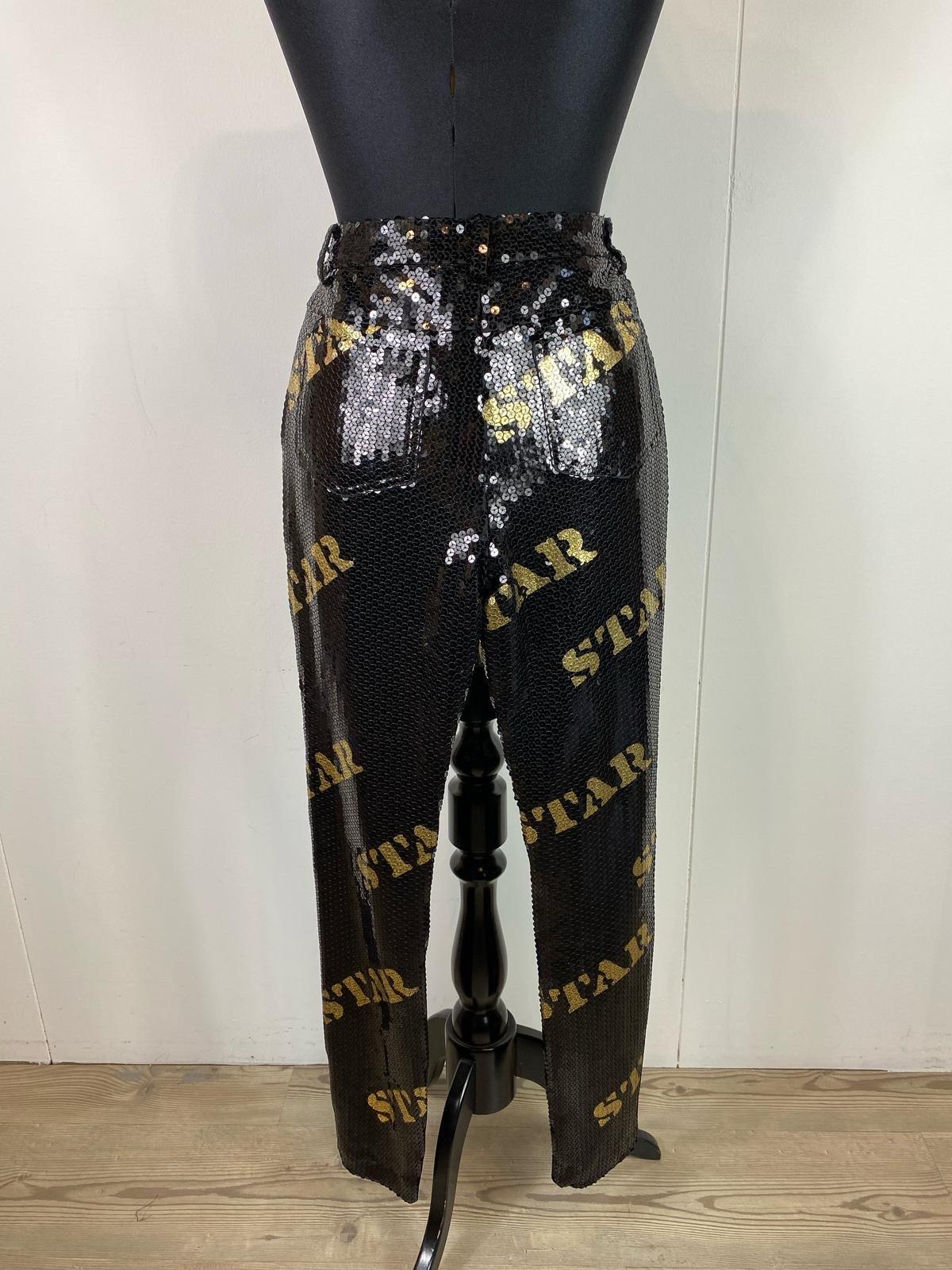 Moschino Couture trousers in black sequins with gold lettering
Slightly stretchy.
Italian size 42 in polyester.
In perfect condition
Size 42
Waist 38 cm
Pelvis 46 cm
Total length 98 cm