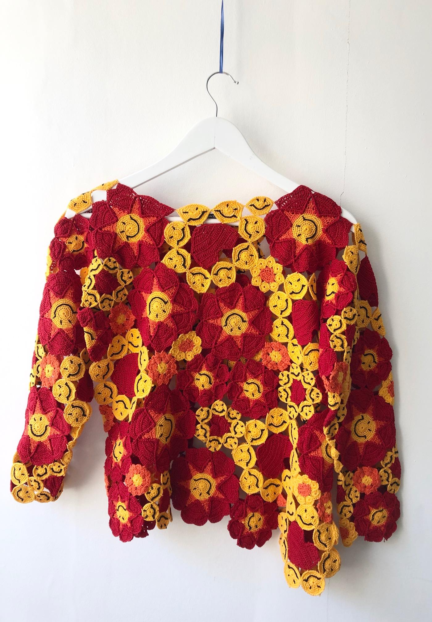 Authentic Moschino Vintage Crochet Smiley face sweater, asymmetrical hemline, classic fit, red, orange and red floral and happy face pattern, long sleeves, round neck, cotton 
Condition: vintage. excellent, 1990s
Size S-M
Measures: 18.5 inches from
