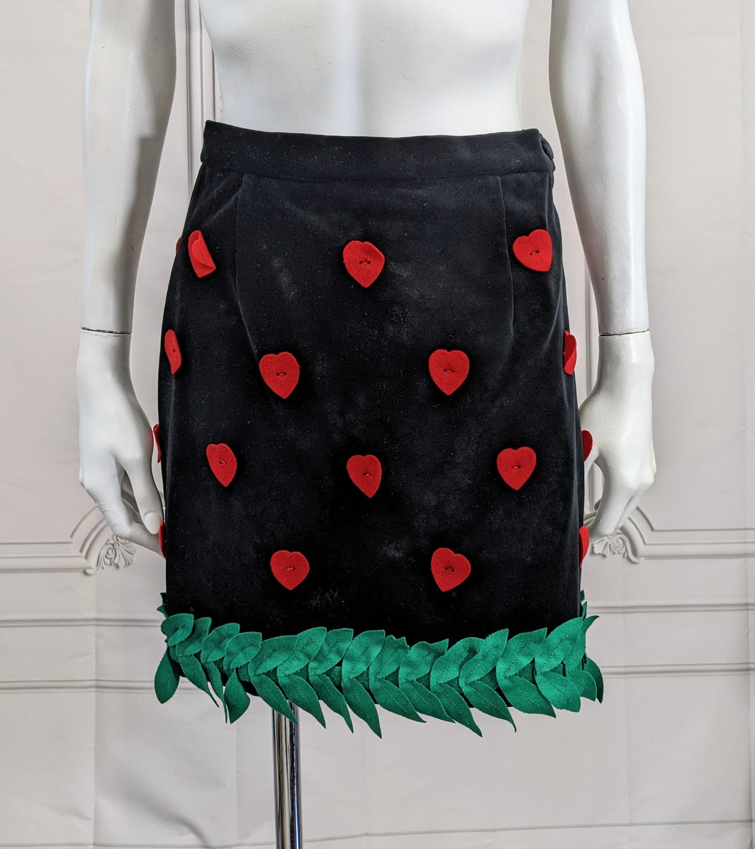 Moschino Festive Velvet Heart and Leaf Mini Skirt from the 1990's. Cotton velvet with red felt hearts and a felt hem of green garlands. USA Vintage 10. 
See measures for modern fit. Waist 25