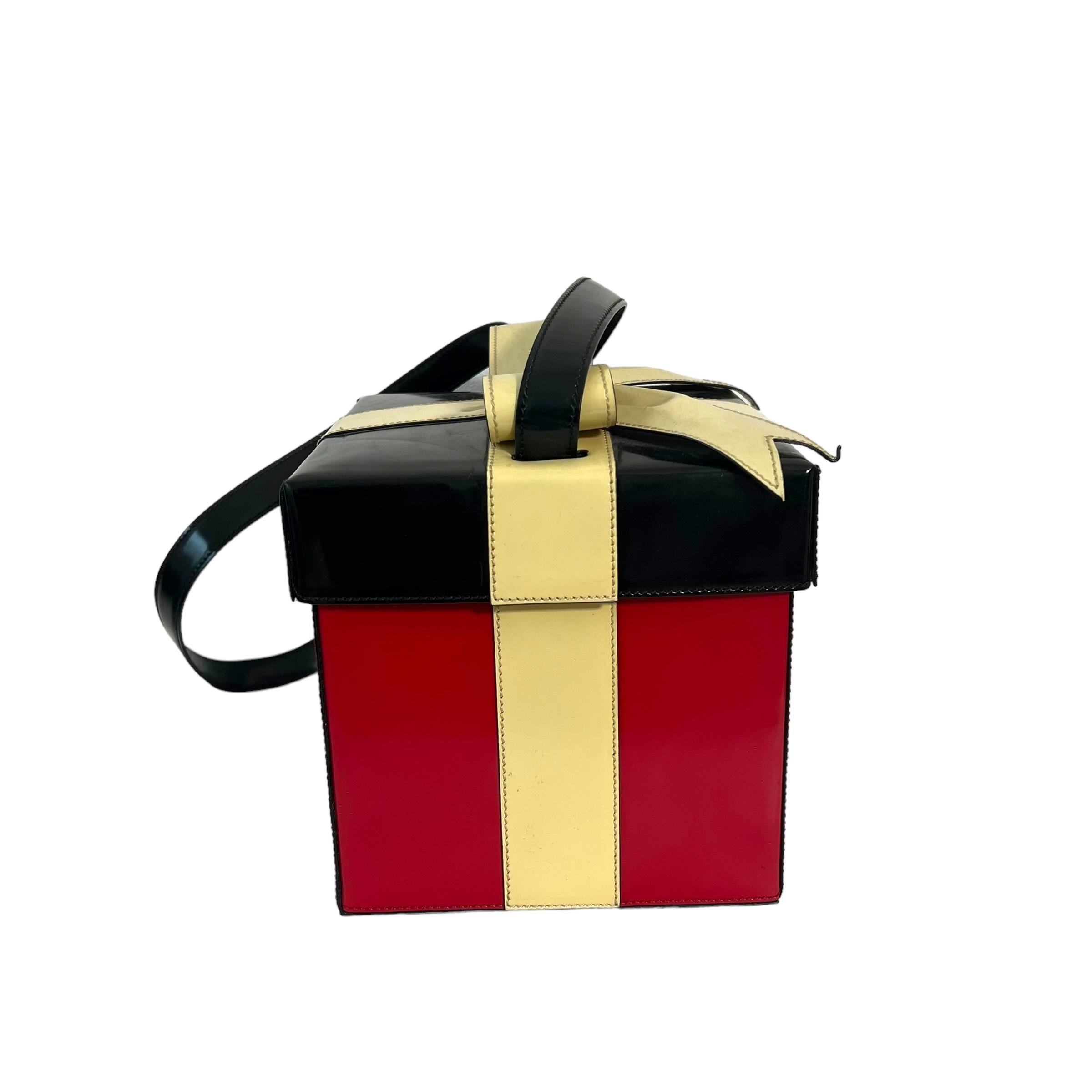 
This Moschino handbag is a rare vintage piece, perfect for the holidays! Made in Italy, the black and red colors with a gorgeous ribbon detailing truly give it the look of a gift. As a collector's item from the 90s, its pre-owned condition adds to