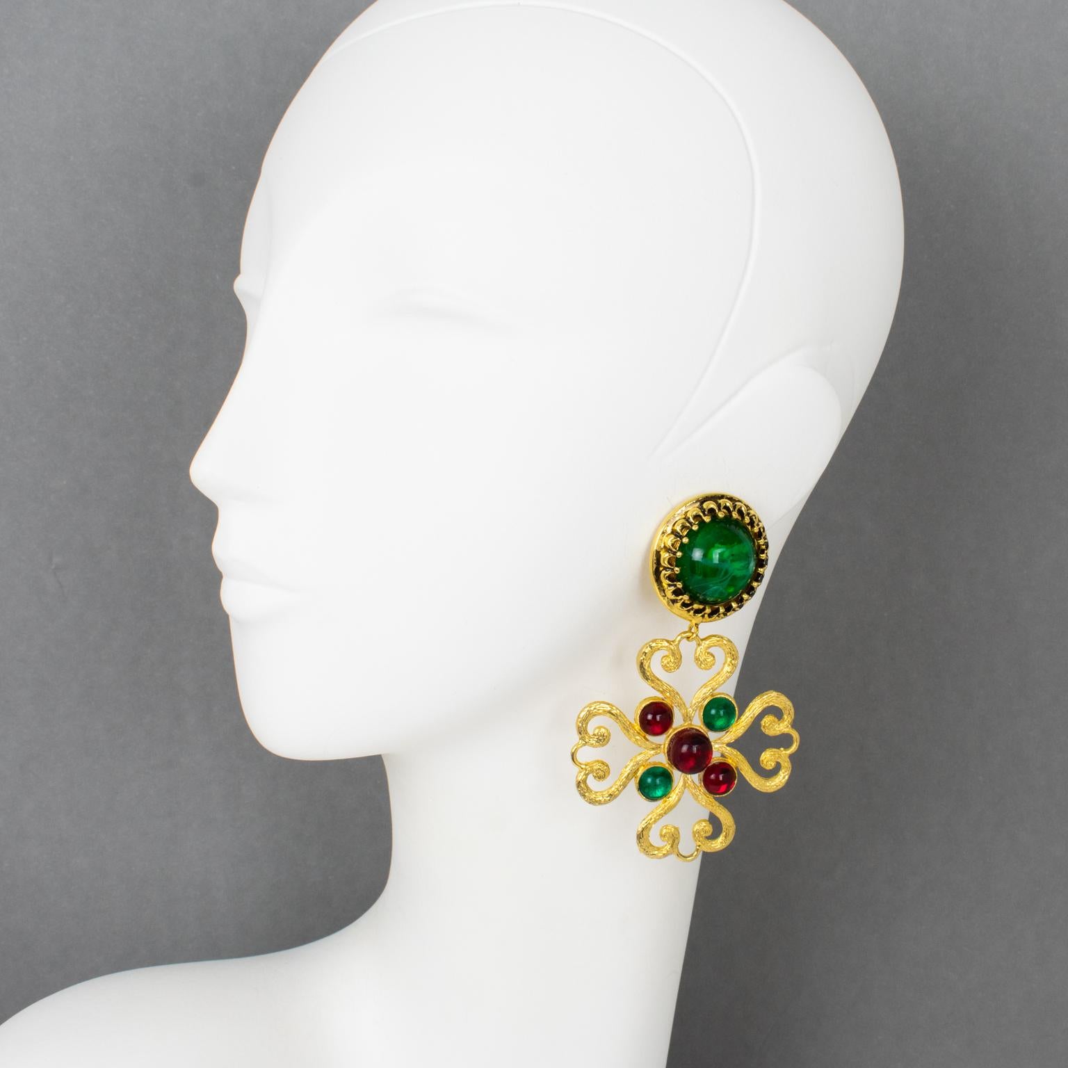 Moschino, Italien, entwarf diese exquisiten baumelnden Ohrringe zum Anstecken. Die Stücke weisen ein übergroßes stilisiertes Malteserkreuz-Design in vergoldetem Metallrahmen auf, das mit Harzcabochons in rubinroten und smaragdgrünen Marmorfarben