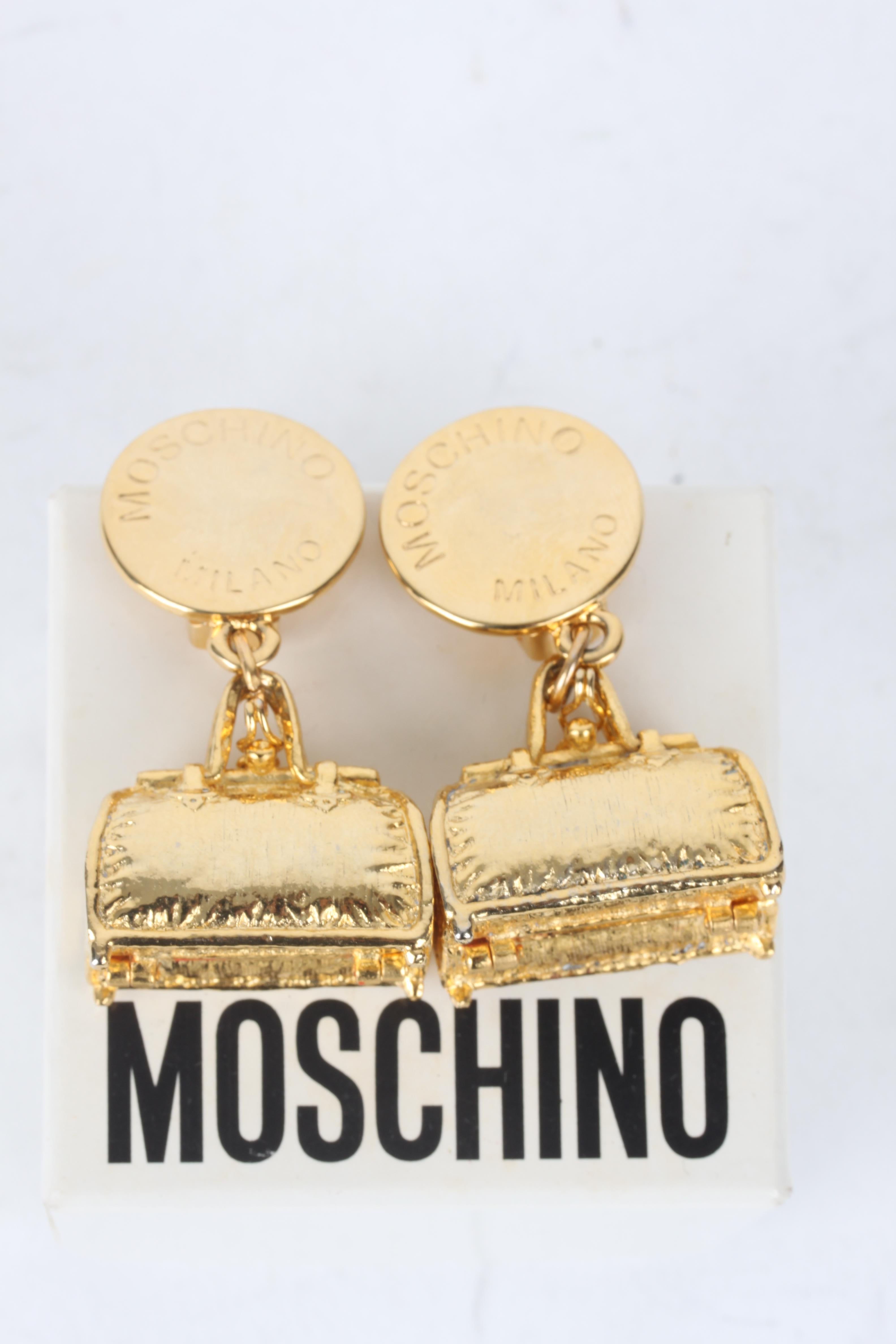 Moschino Gold-Plated Bag Charm Clip-On Earrings.

These earrings feature a lux gold-plated bag-charm exterior with a matching glossy finish. The earrings feature a gold-plated backside clip fastening. Bag charm opens up to a red velvet interior. The