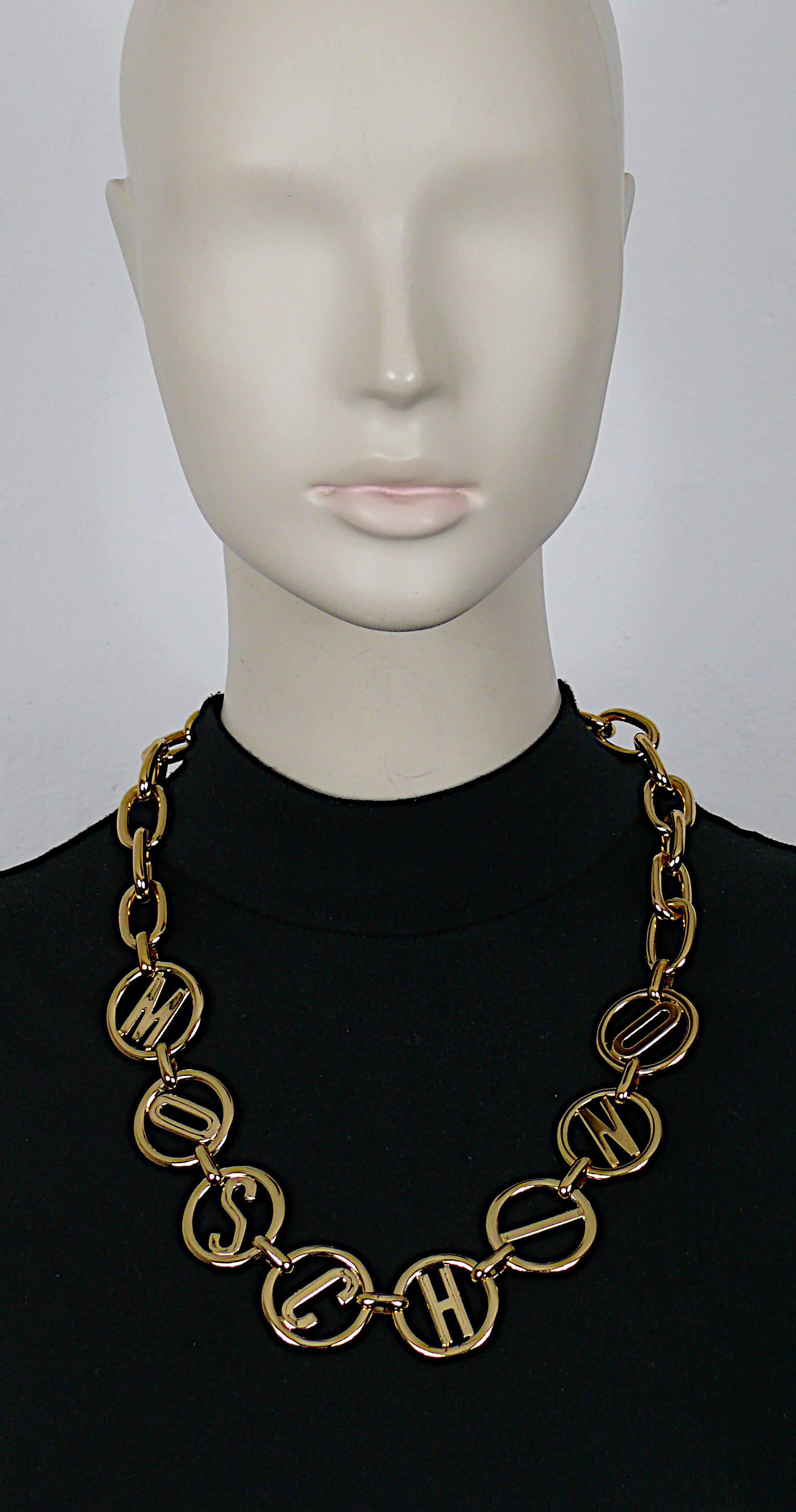 MOSCHINO gold tone chain necklace featuring eight round M O S C H I N O links.

Lobster clasp closure.

Embossed MOSCHINO Made in Italy.

Indicative measurement : length approx. 60.5 cm (23.82 inches) / diameter of the round links approx. 3 cm (1.18